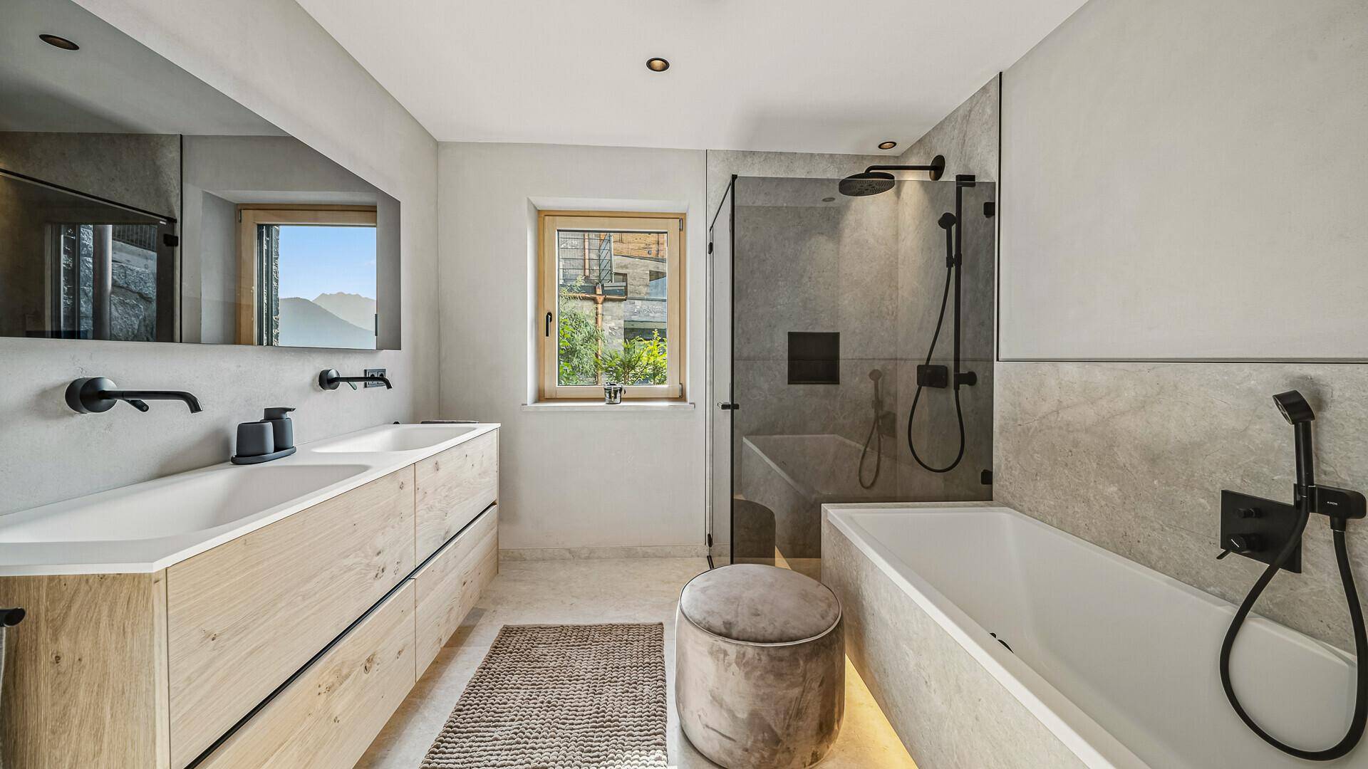 Modernes Badezimmer mit Badewanne, begehbarer Dusche, Doppelwaschbecken und Fenster.