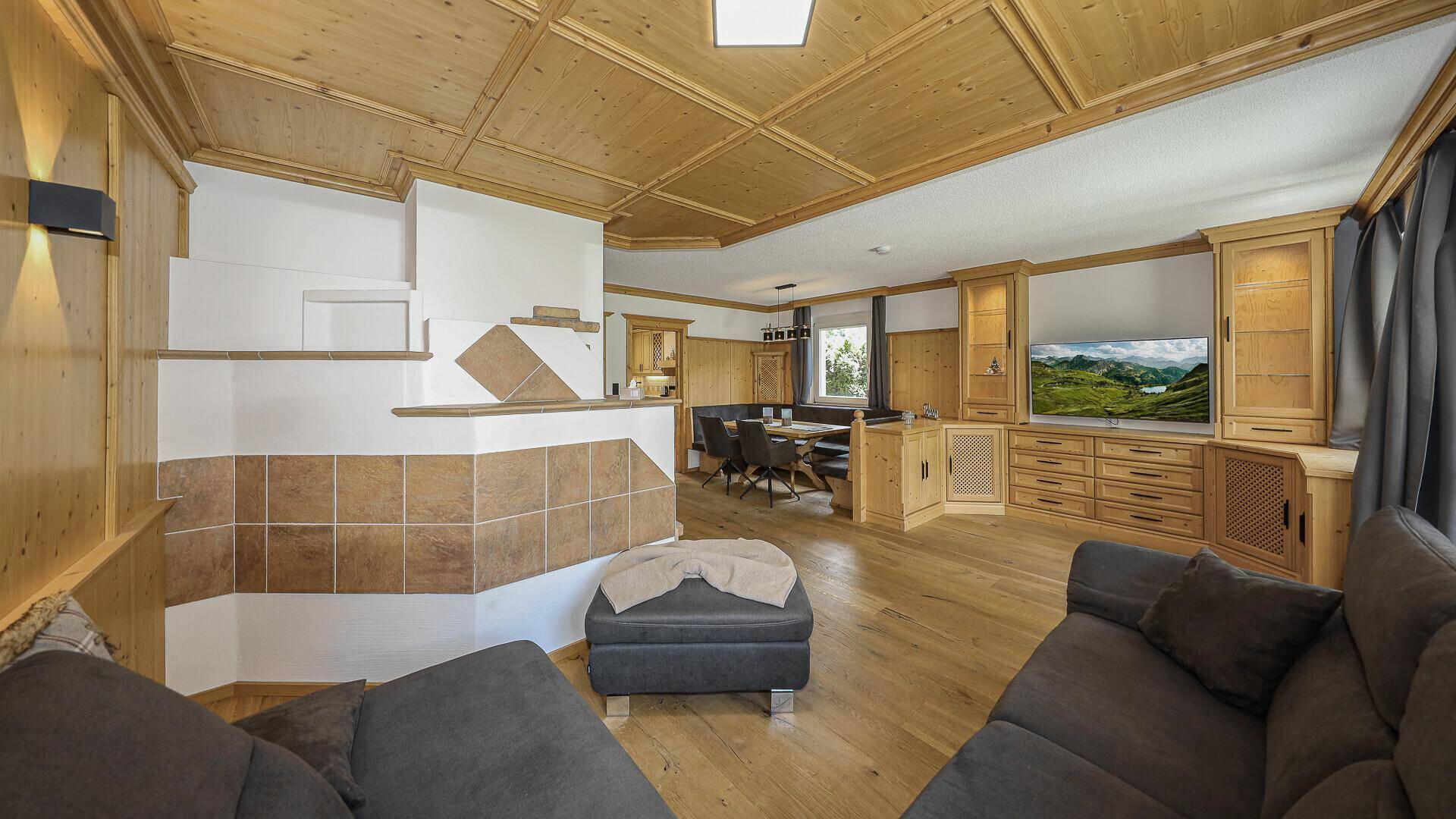 Geräumiger Wohn-Essbereich mit Holzboden, Kamin und traditioneller Holztäfelung an Wänden und Decke.
