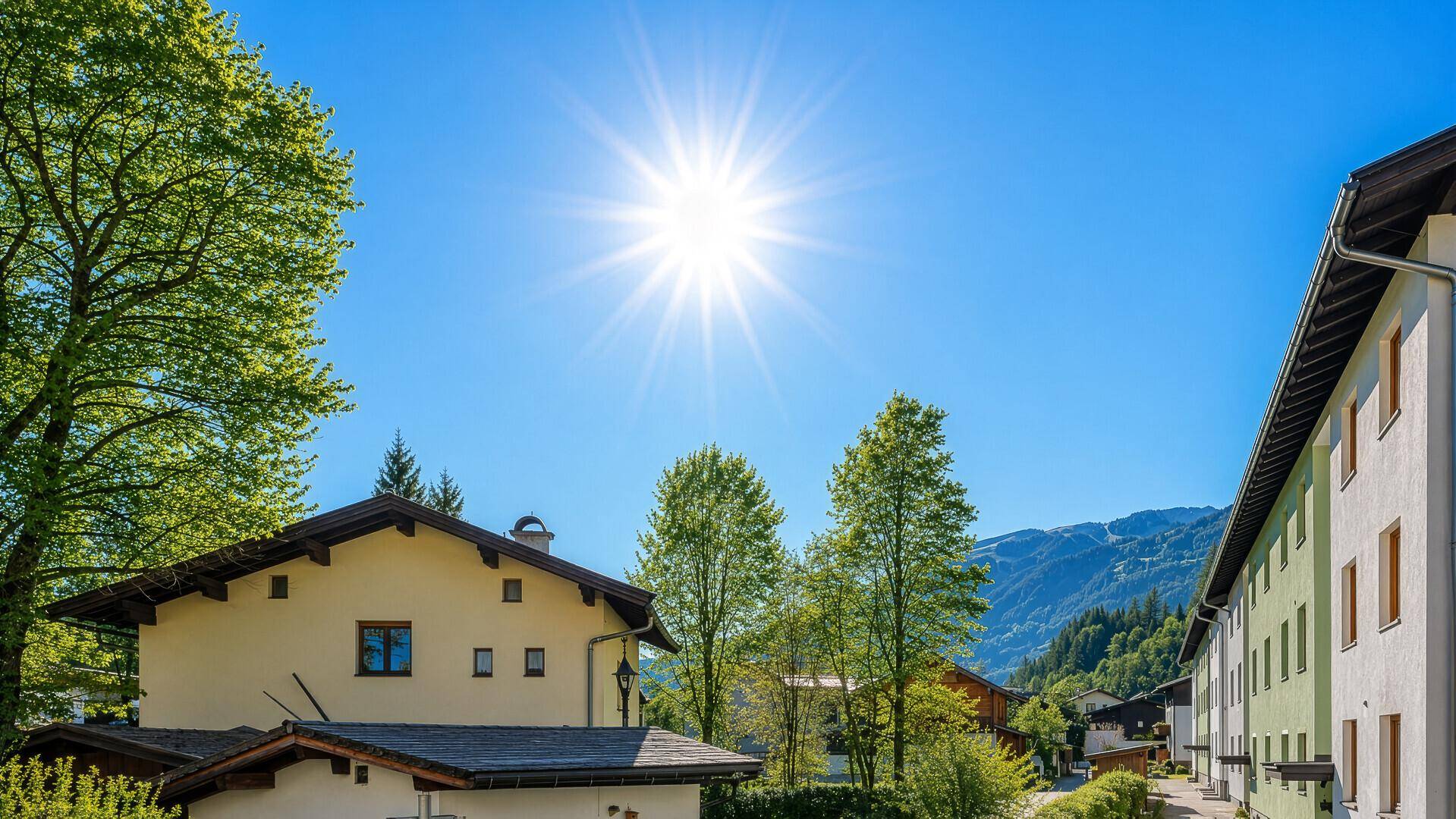 Sonnige Außenansicht eines Gebäudes in den Bergen mit grüner Umgebung.