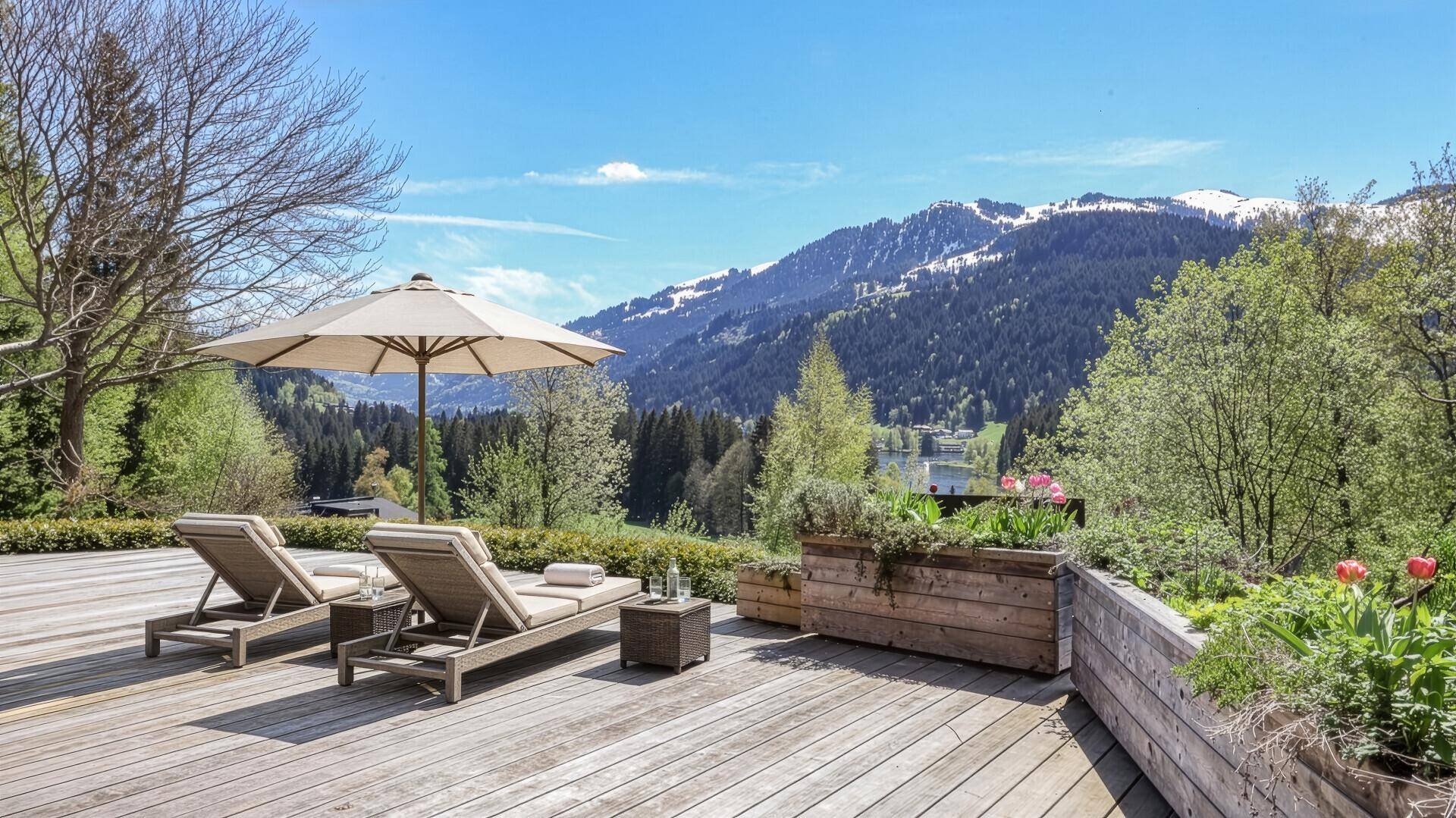 Geräumige Holzterrasse mit Liegestühlen und Sonnenschirm, bietet einen atemberaubenden Bergblick.