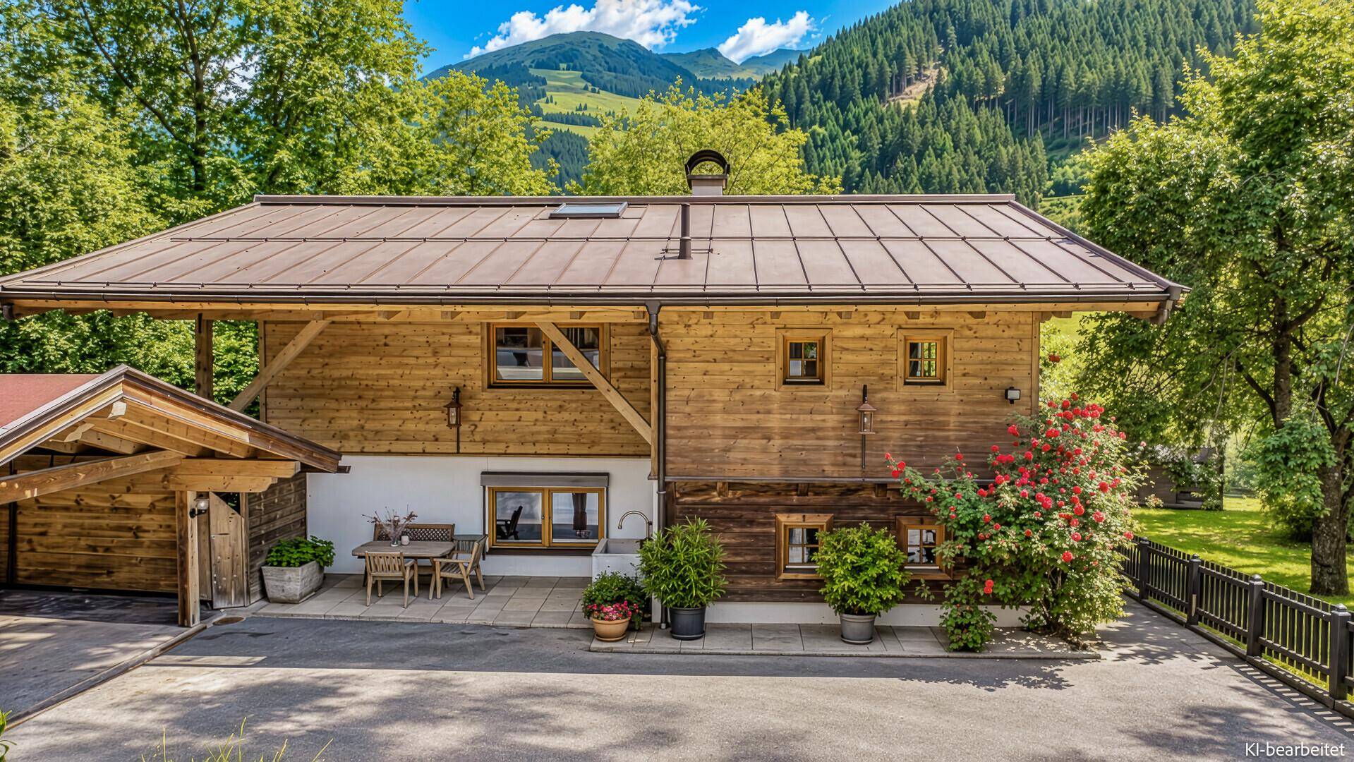 Rückseite des Holzhauses mit Terrasse, Esstisch und Blick auf den Gartenbereich.