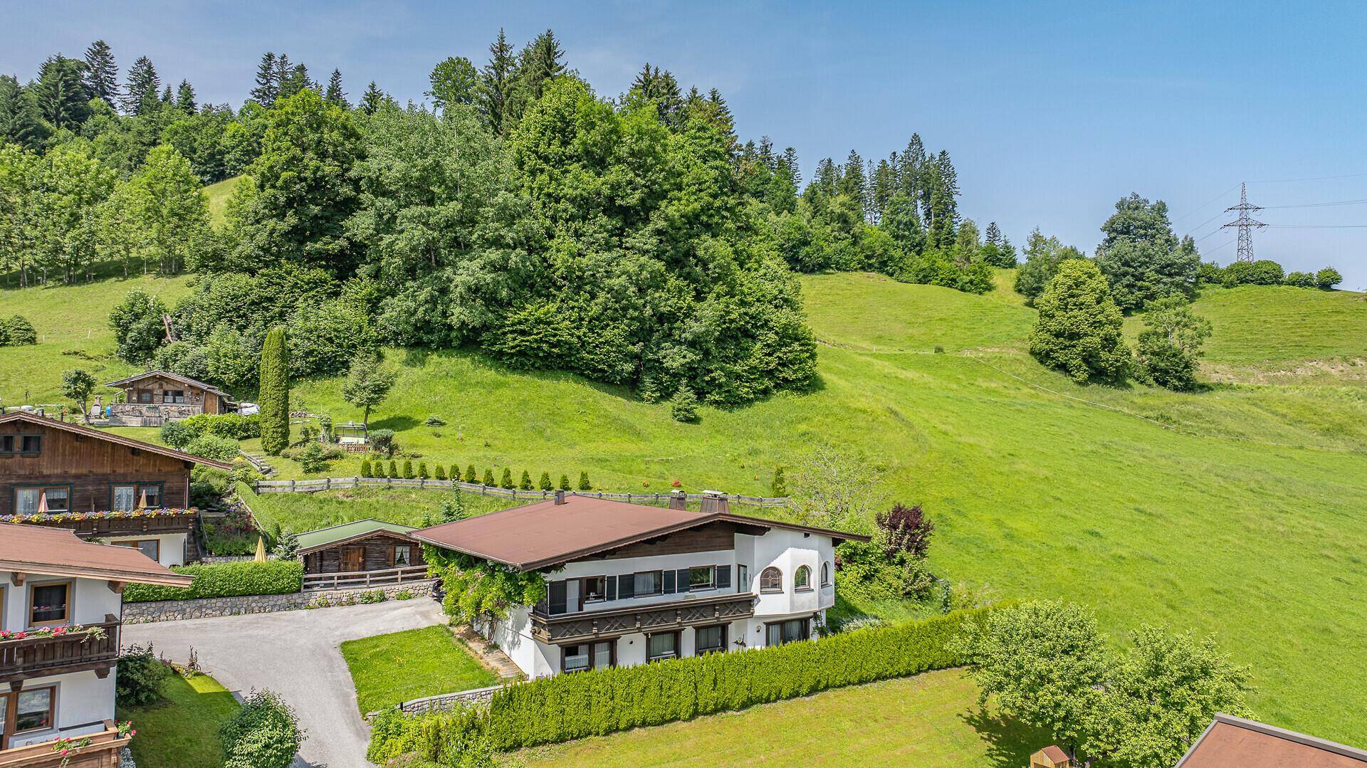Traditionelles Haus mit üppiger Begrünung und gepflegtem Garten in alpiner Umgebung.