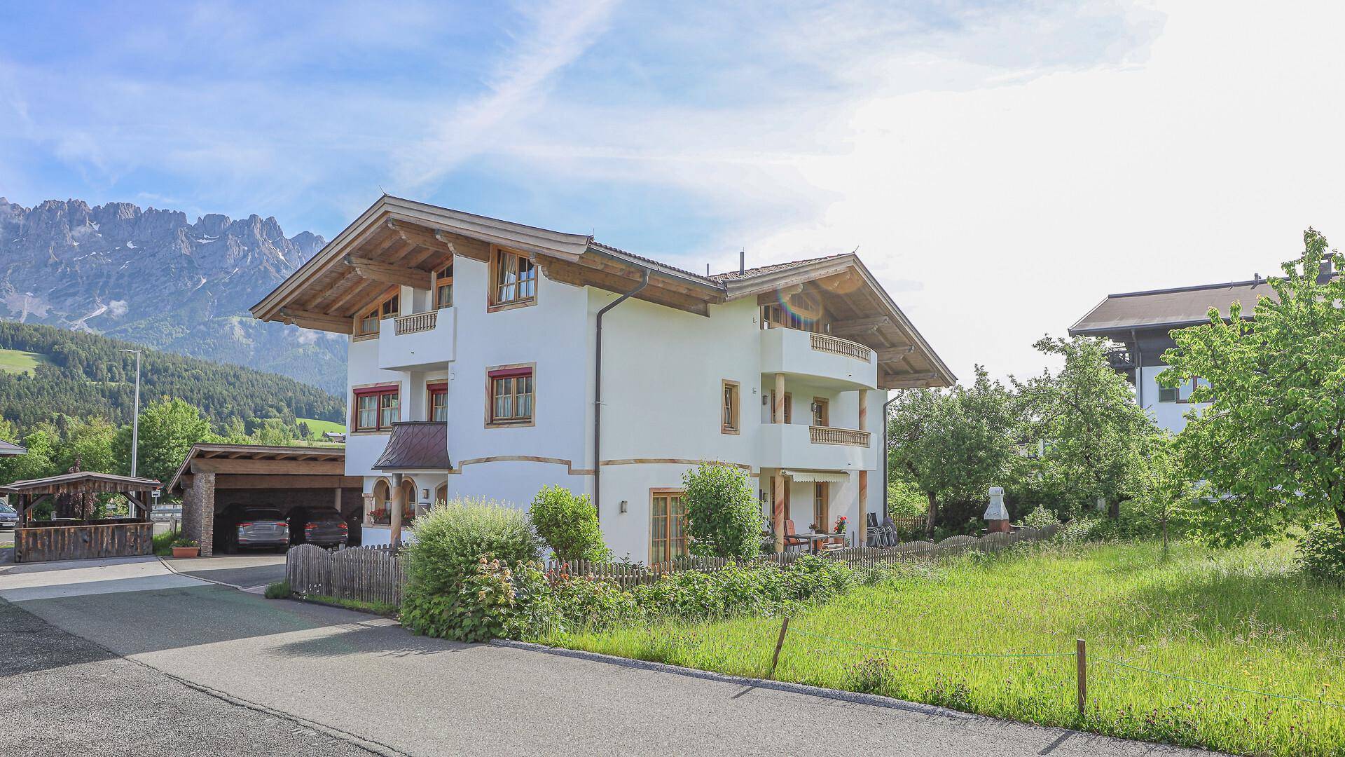 Traditionelles Haus in den Alpen mit Bergblick und umliegender Natur.