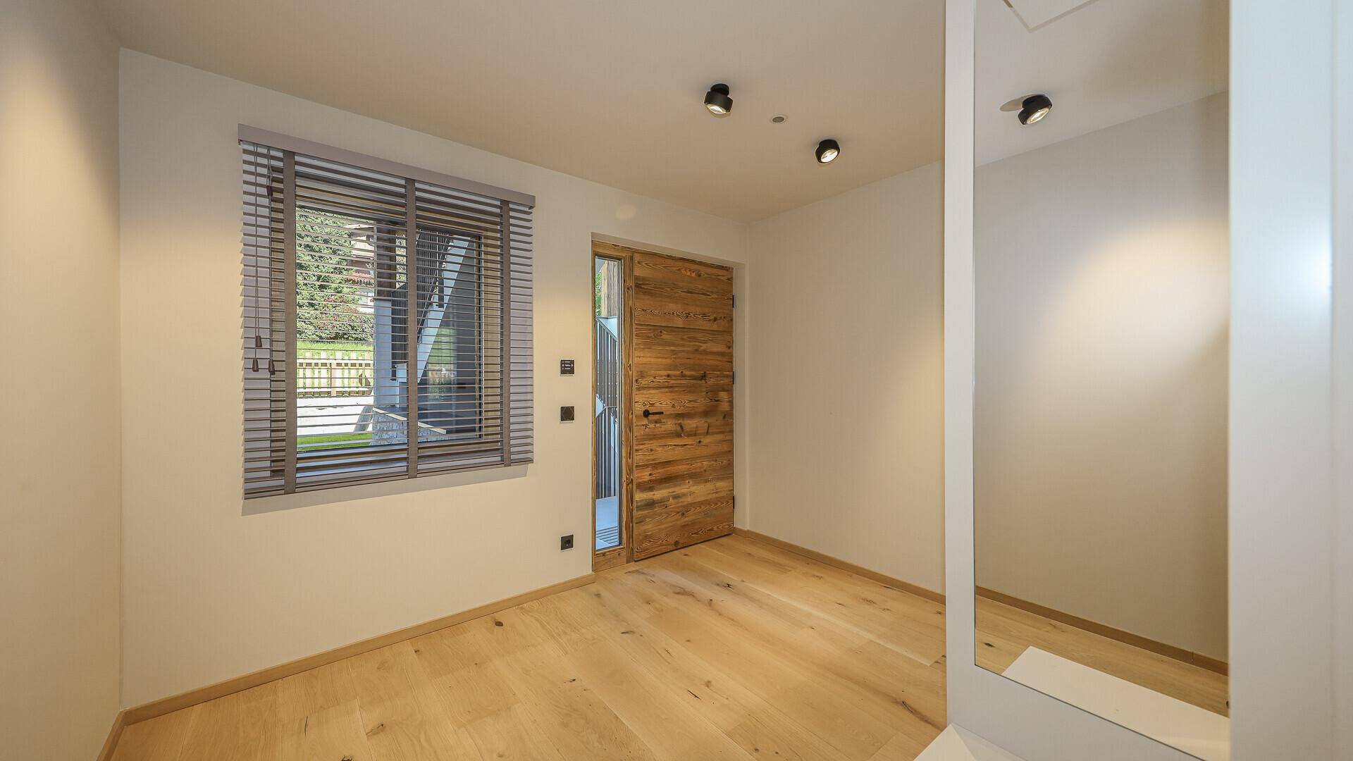 Heller Raum mit Holzboden und Fenster, ideal als Schlaf- oder Arbeitszimmer.