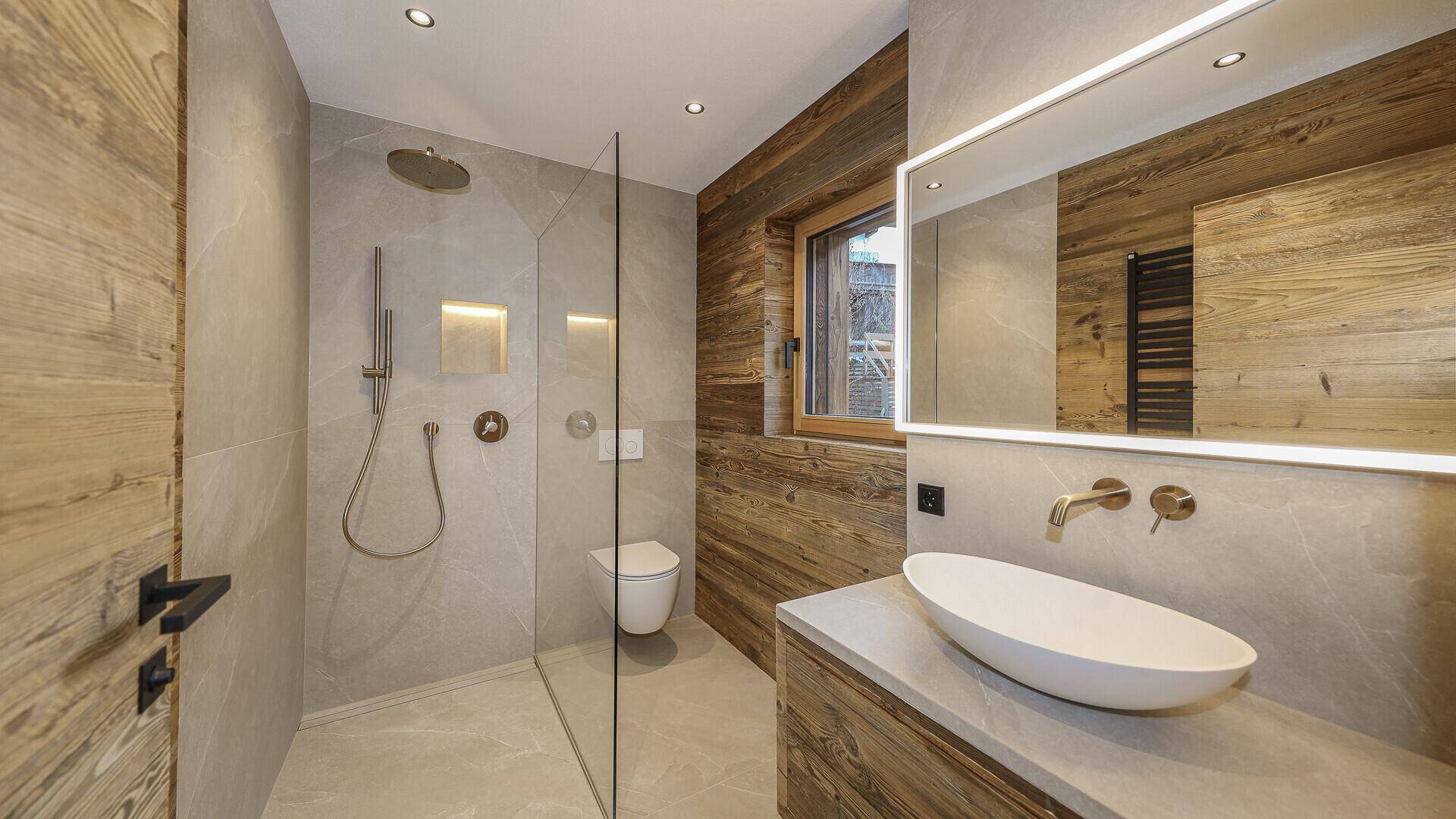 Modernes Badezimmer mit begehbarer Dusche, Waschtisch und Holzakzenten.