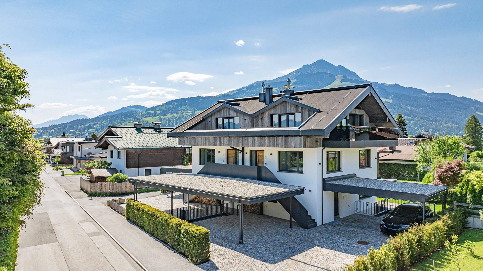 Großzügiges Haus mit Bergblick, zwei Carports und gepflegter Umgebung.