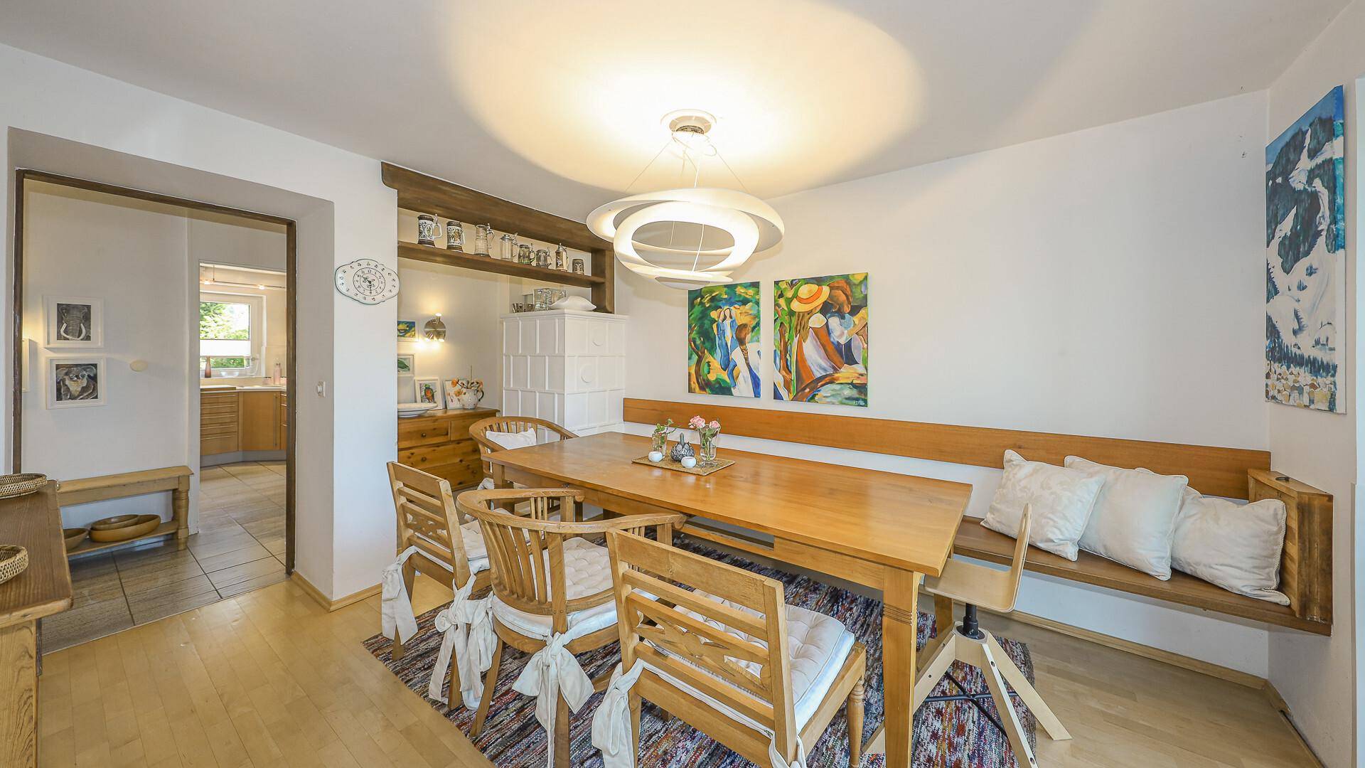 Traditioneller Essbereich mit Holztisch, Sitzbank und moderner Deckenleuchte.