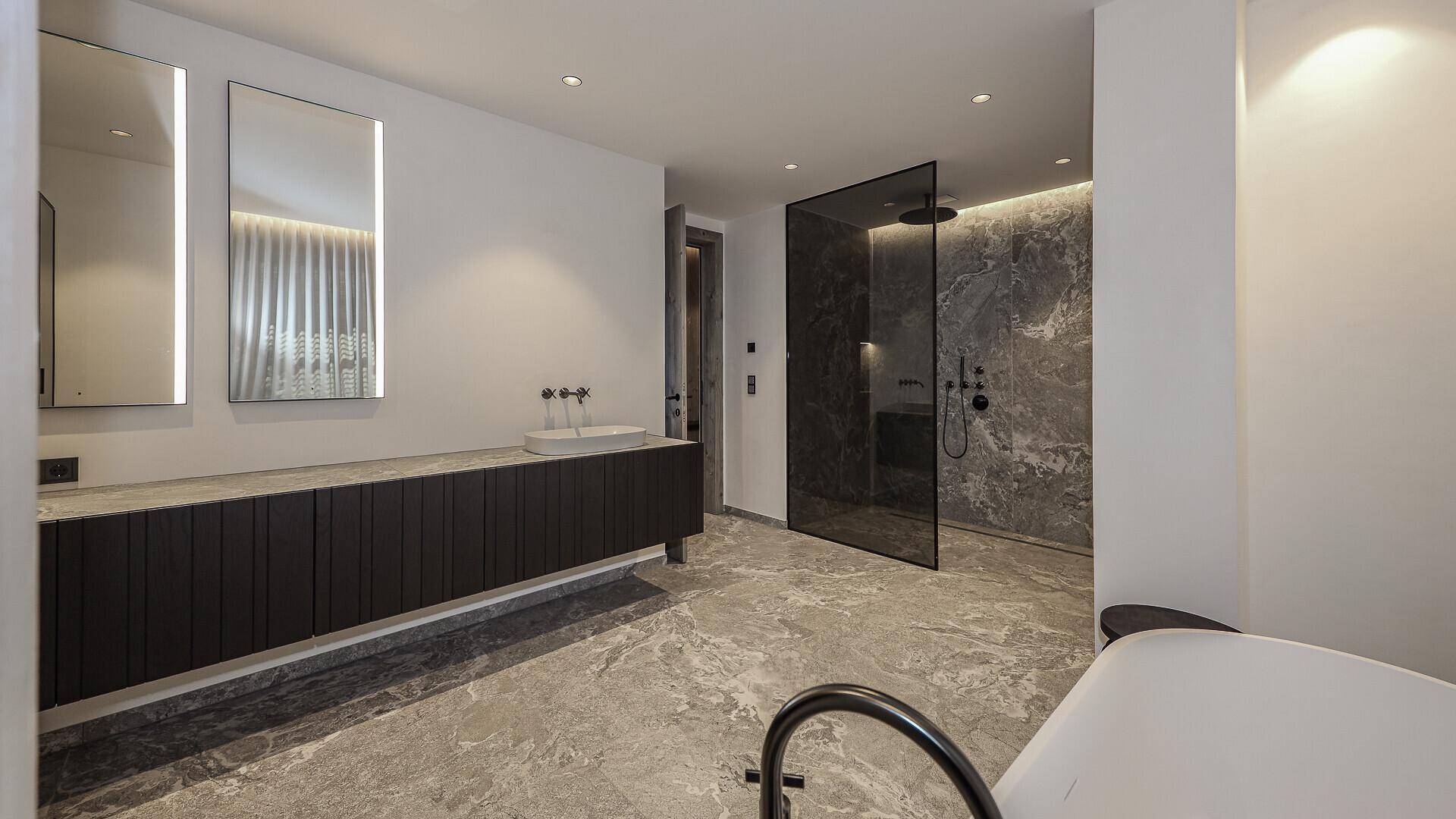 Luxuriöses Badezimmer mit Doppelwaschbecken, freistehender Badewanne und großer begehbarer Dusche.