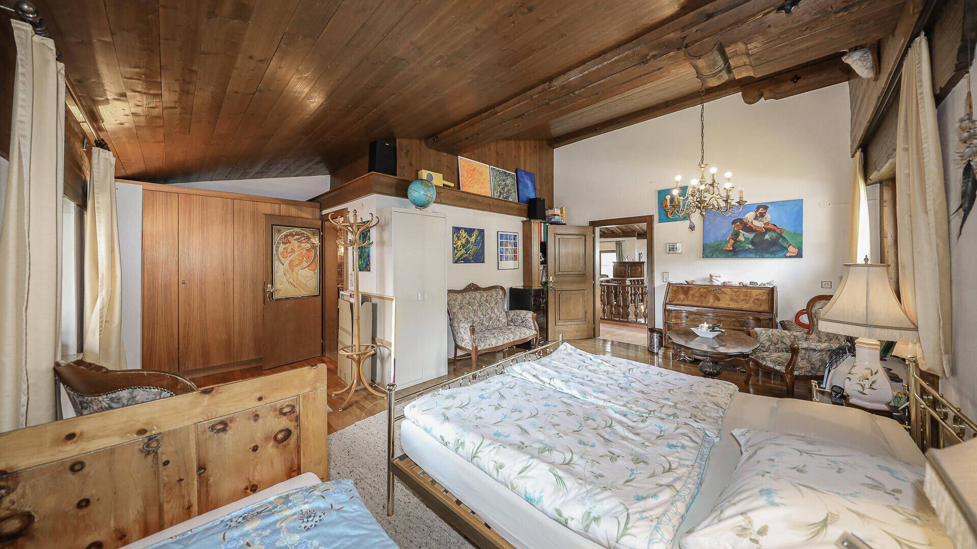 Großes Schlafzimmer mit Holzbalkendecke, Parkettboden und traditioneller Einrichtung.