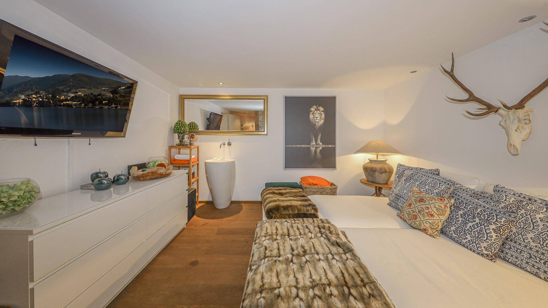 Helles Schlafzimmer mit Holzboden, Fernseher und dekorativer Steinwand, modern eingerichtet.