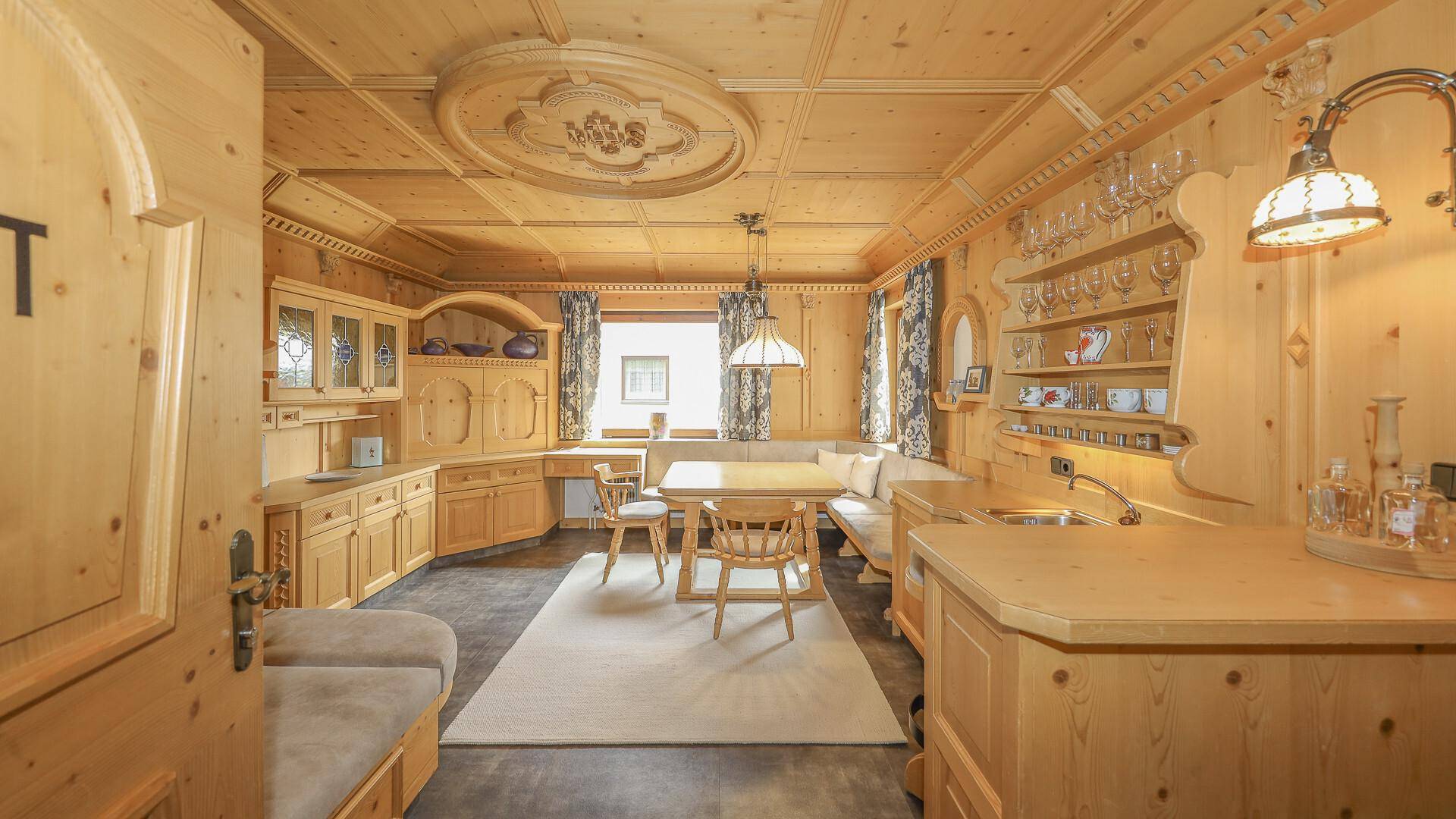 Rustikaler Essbereich mit integrierter Küchenzeile, komplett aus hellem Holz gefertigt und mit traditionellen Details.