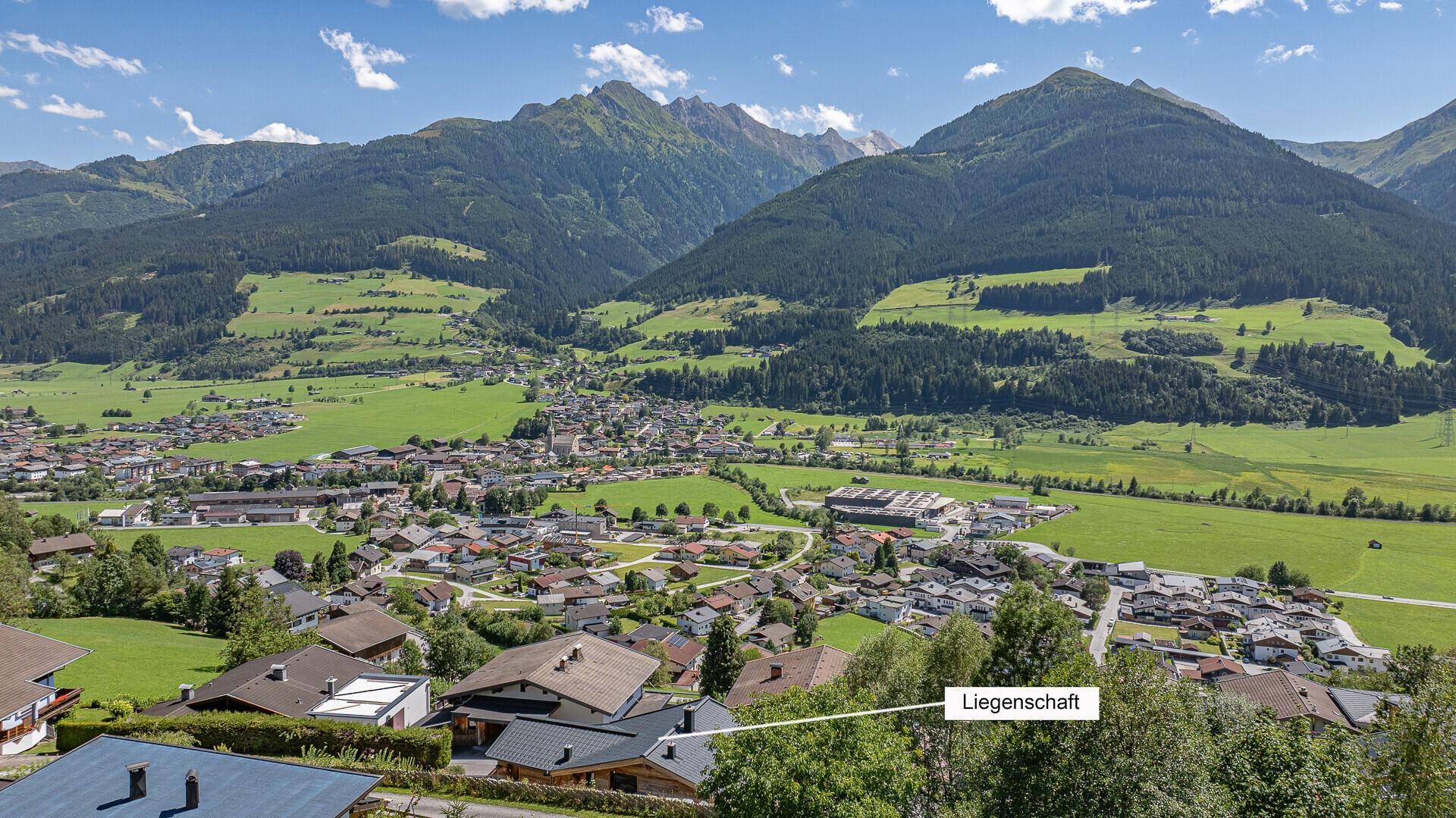 Weitläufige Luftaufnahme der Liegenschaft eingebettet in eine malerische Bergkulisse.