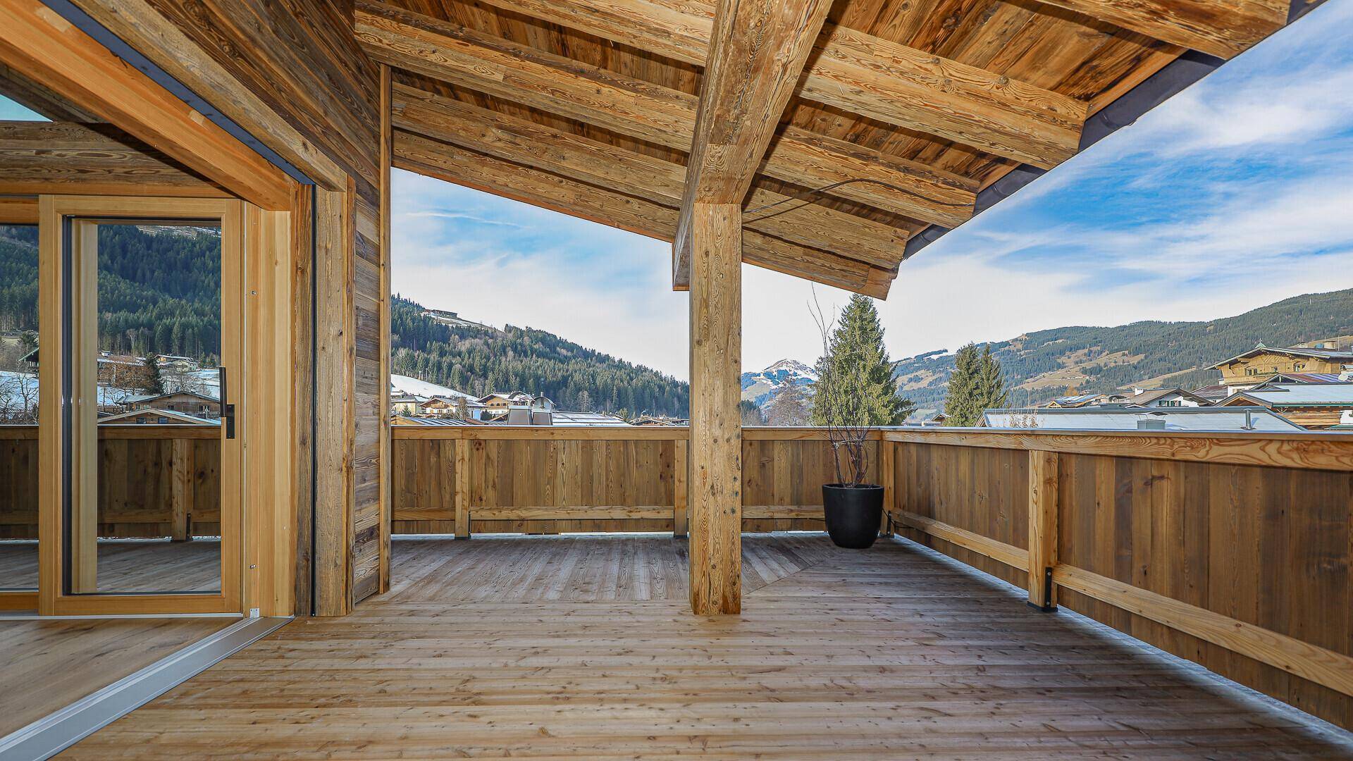 Große Holzterrasse mit Bergblick, ideal für entspannte Stunden im Freien.
