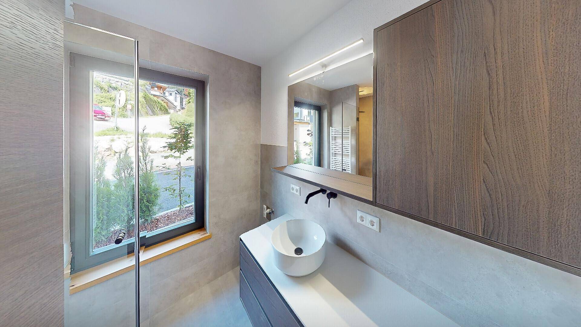 Modernes Badezimmer mit Einzelwaschbecken, Spiegelschrank und Fenster für Tageslicht.