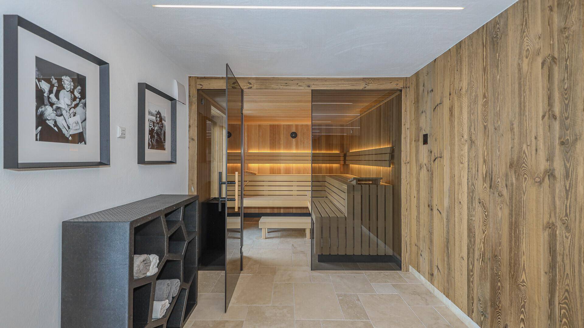 Hochwertige Sauna mit Holzbänken und stimmungsvoller Beleuchtung im Wellnessbereich.