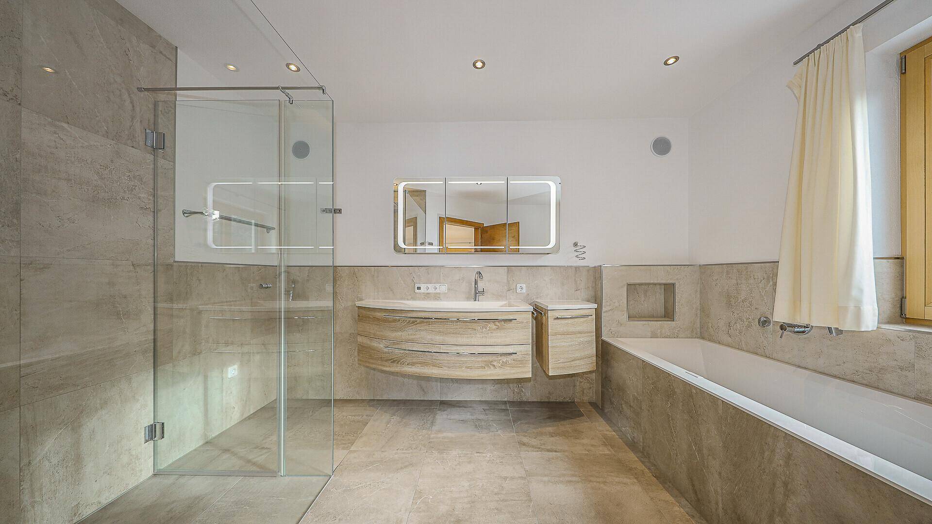 Modernes Badezimmer mit begehbarer Dusche, Badewanne und schwebendem Waschtisch.