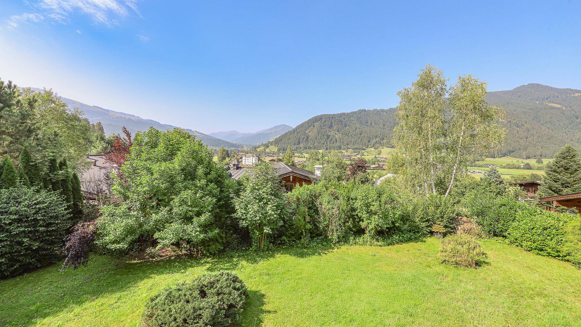 Gepflegter Gartenbereich mit Rasenfläche und weitem Blick auf die umliegende Berglandschaft.