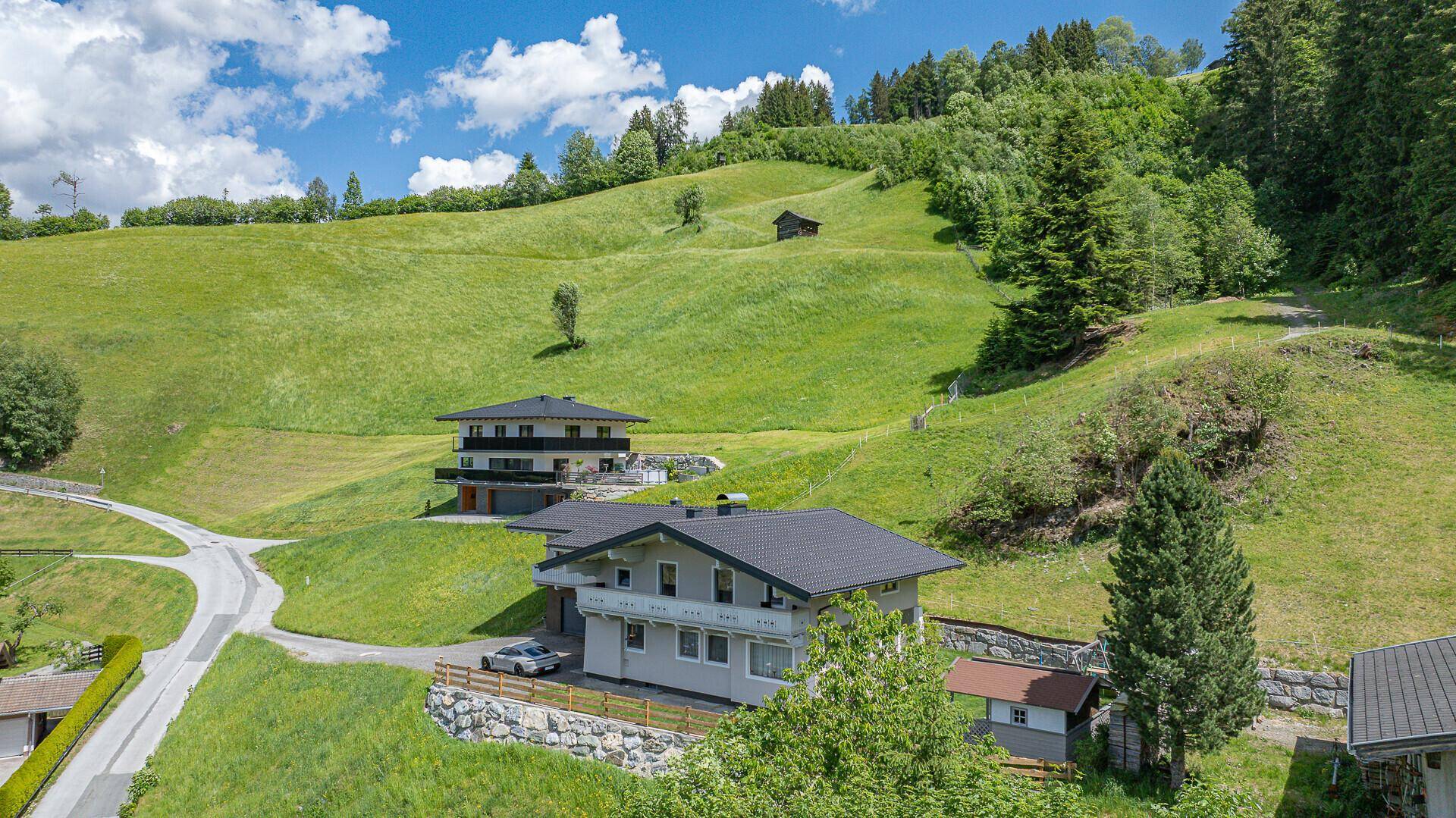 Weitläufiger Blick auf die moderne Architektur der Häuser eingebettet in die idyllische Berglandschaft.