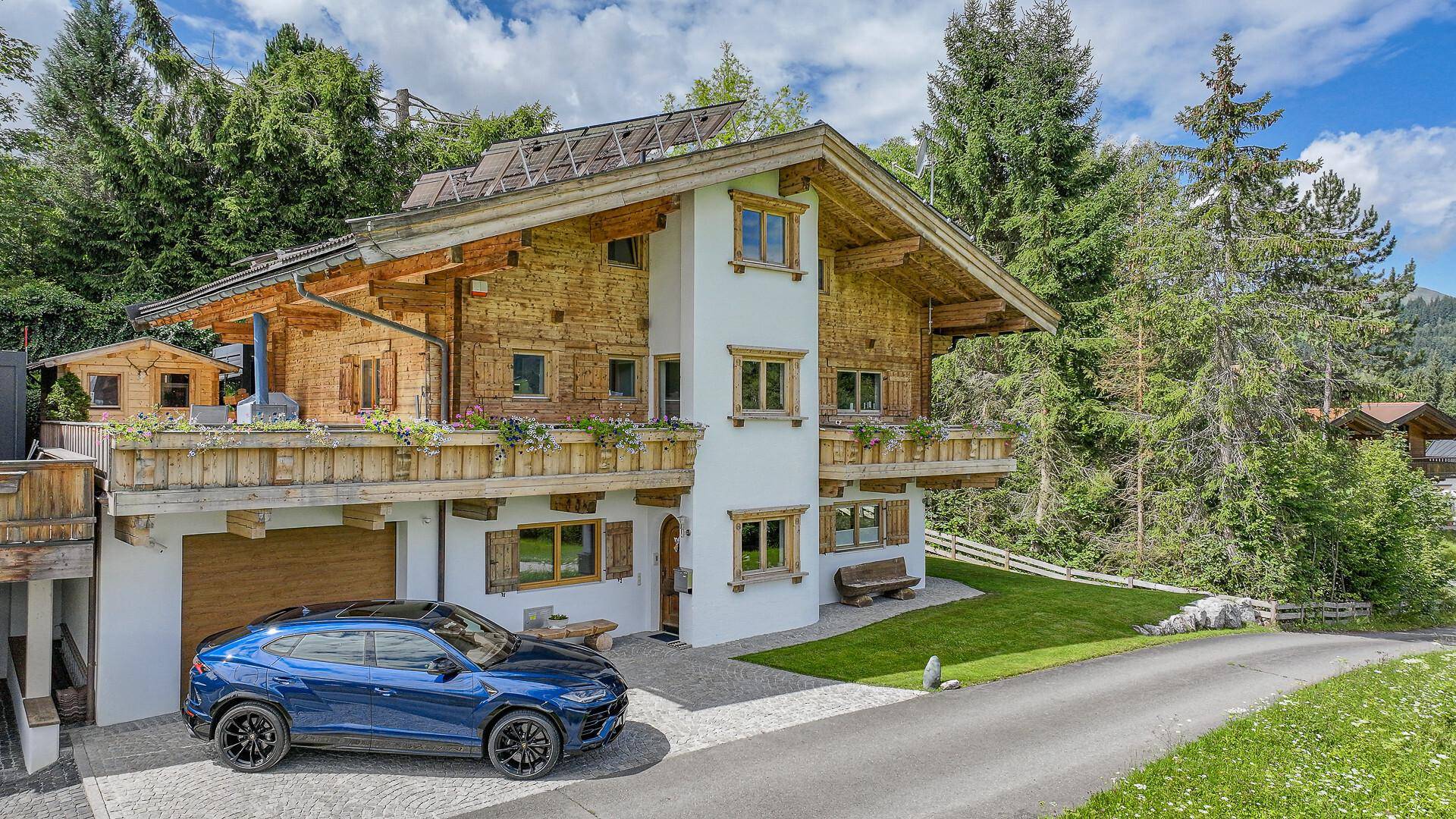Charmantes Chalet-Haus in den Alpen mit Holzfassade und gepflegtem Vorgarten.