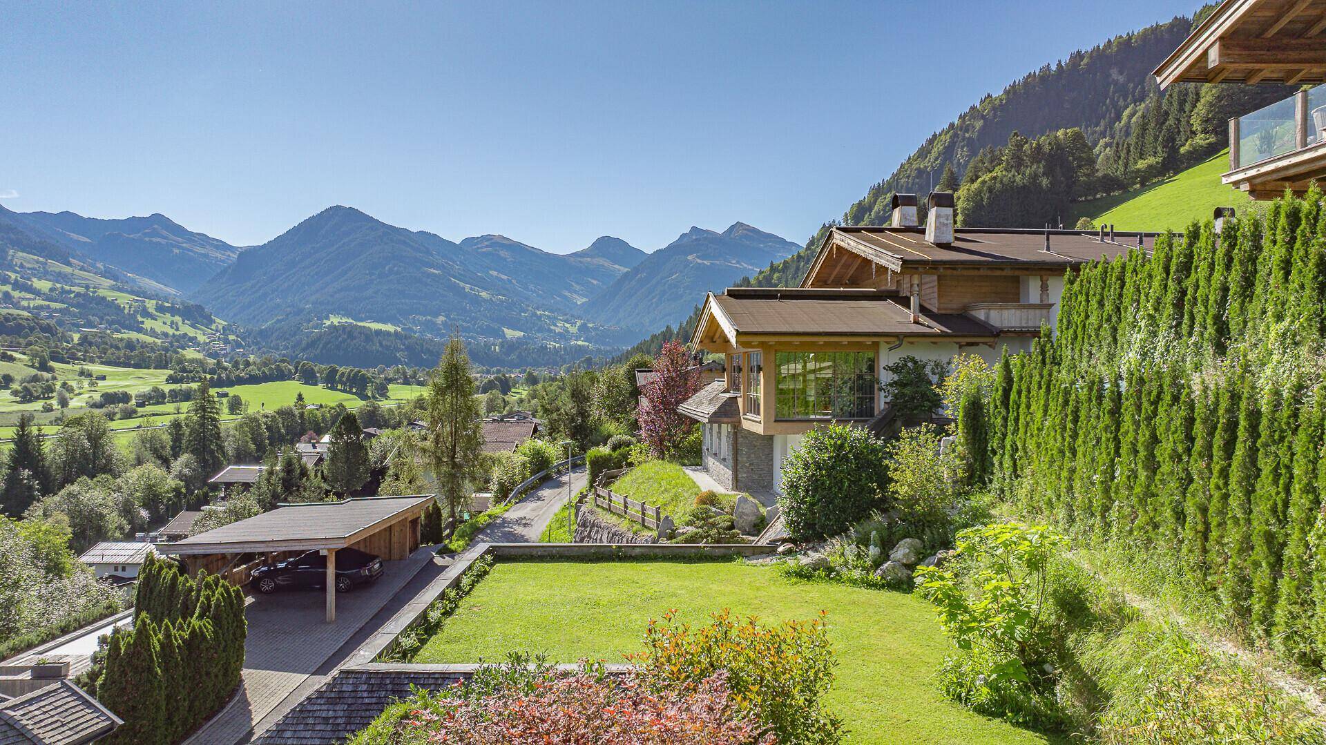Malerischer Blick auf die umliegende Berglandschaft von einem gepflegten Gartenbereich des Anwesens.