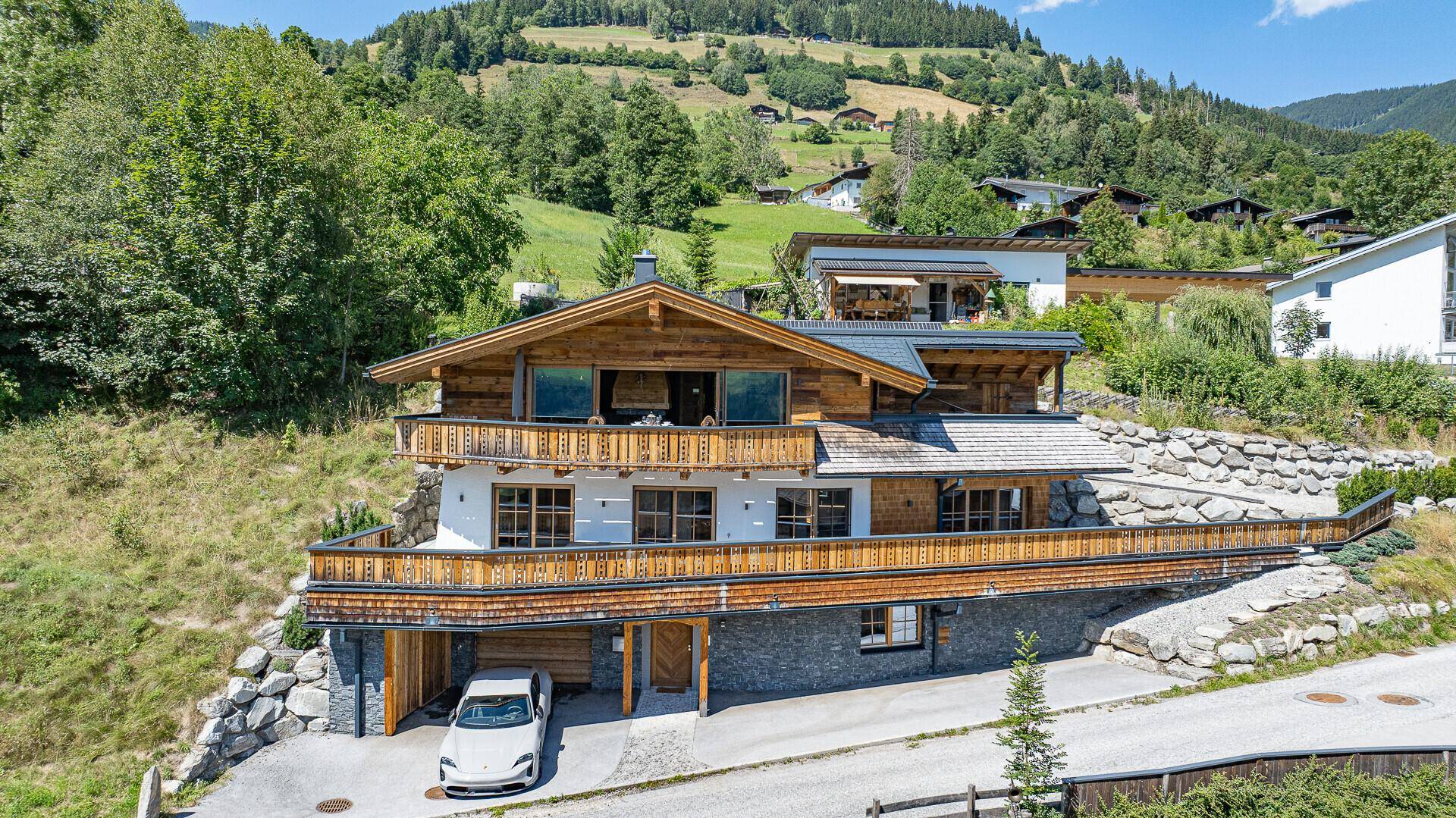 Ansicht des modernen Chalets mit Holzfassade, Balkonen und integrierter Garage.