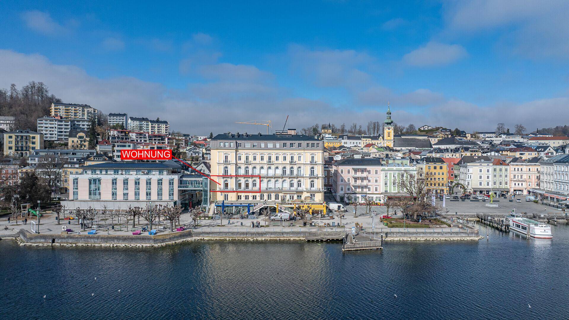 Historisches Gebäude an der Seepromenade mit Blick auf die Stadt und die umliegende Landschaft.