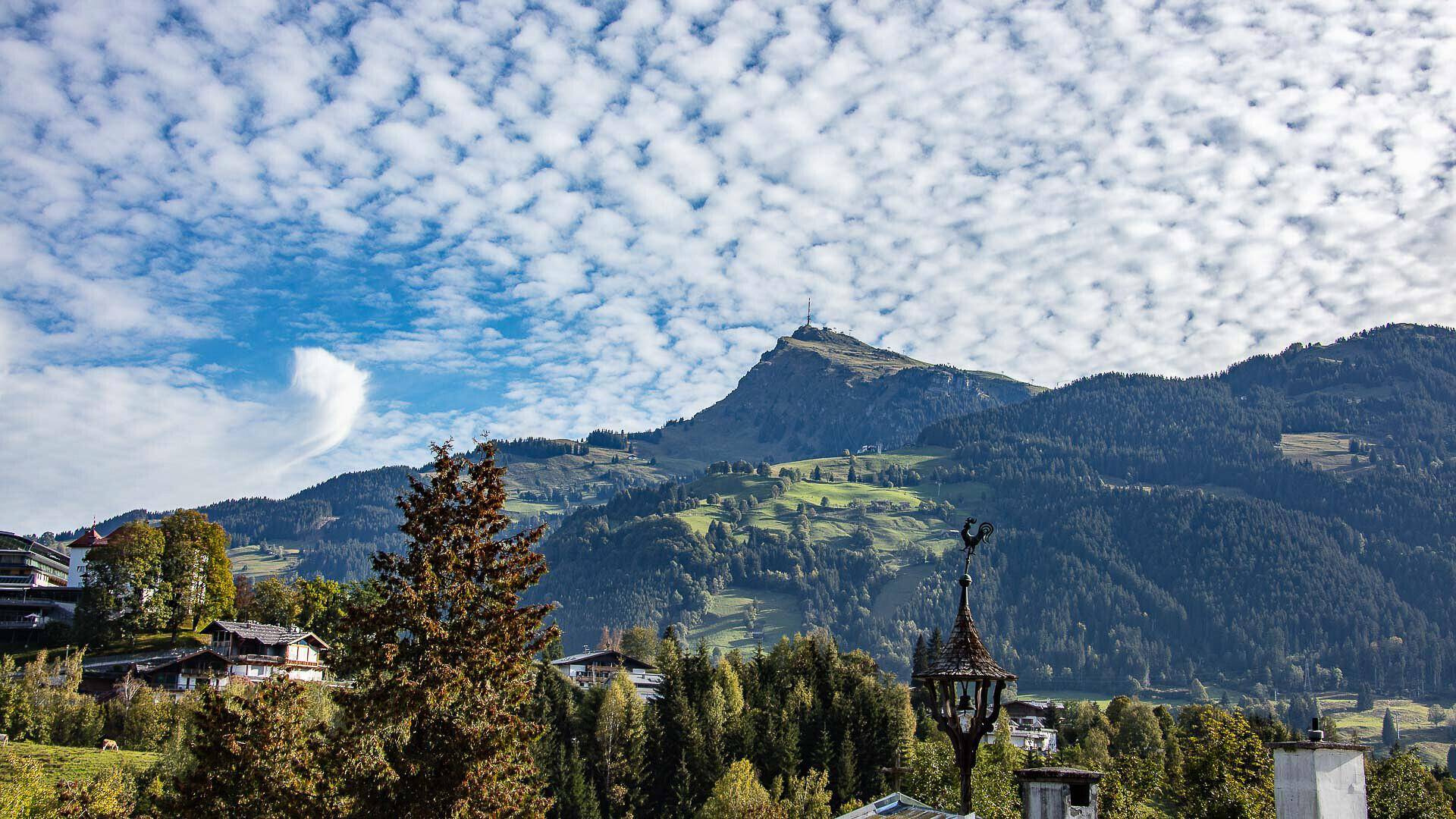 Weitläufiger Blick auf die sanften Hügel und den blauen Himmel mit Wolkenformationen.