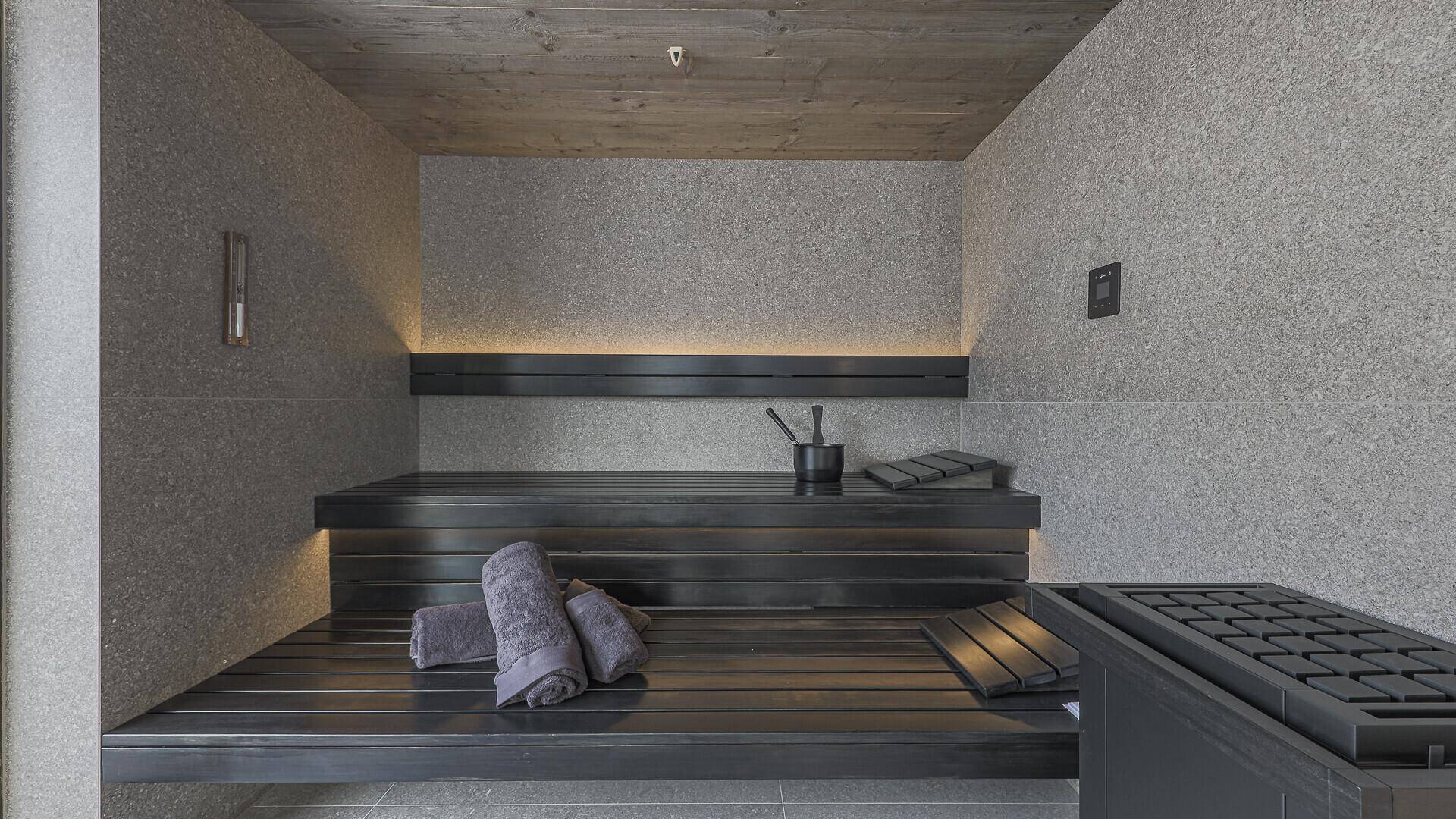 Moderne Sauna mit Holzbänken und indirekter Beleuchtung für entspannende Momente.