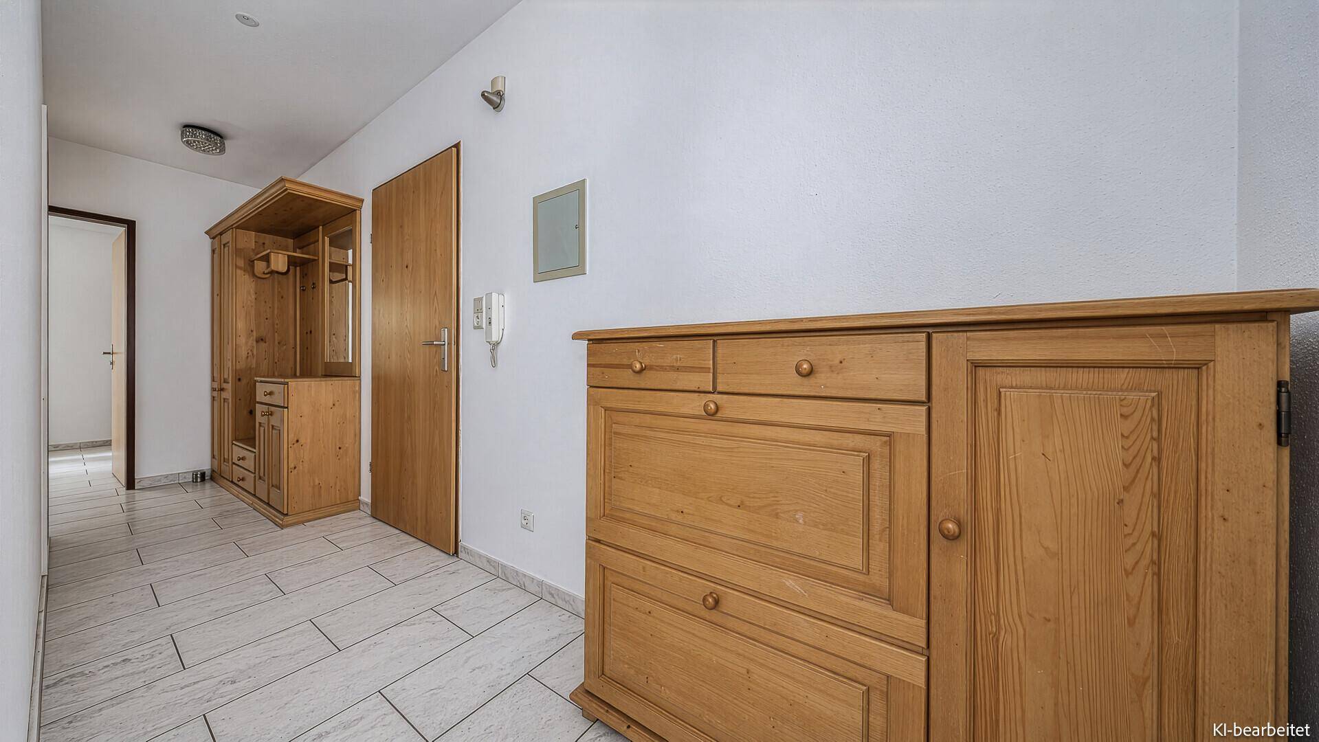 Heller Flur mit Fliesenboden und traditionellen Holzmöbeln, einladend und funktional.
