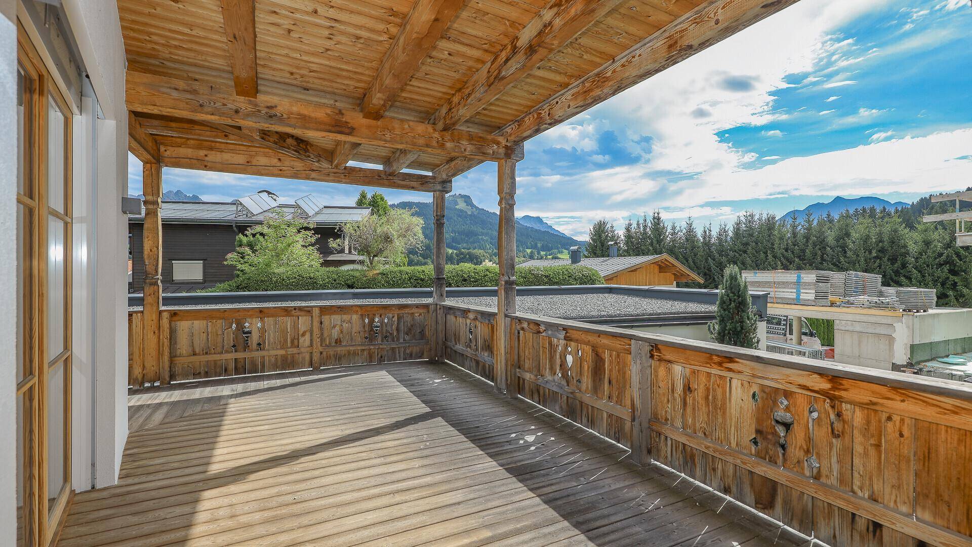 Geräumiger Holzbalkon mit Blick auf die Berge und die umliegende Natur.
