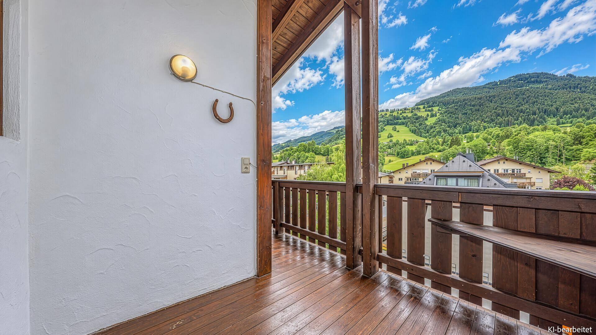 Geräumiger Holzbalkon mit Bergblick und traditionellem Hufeisen-Dekor an der Wand.