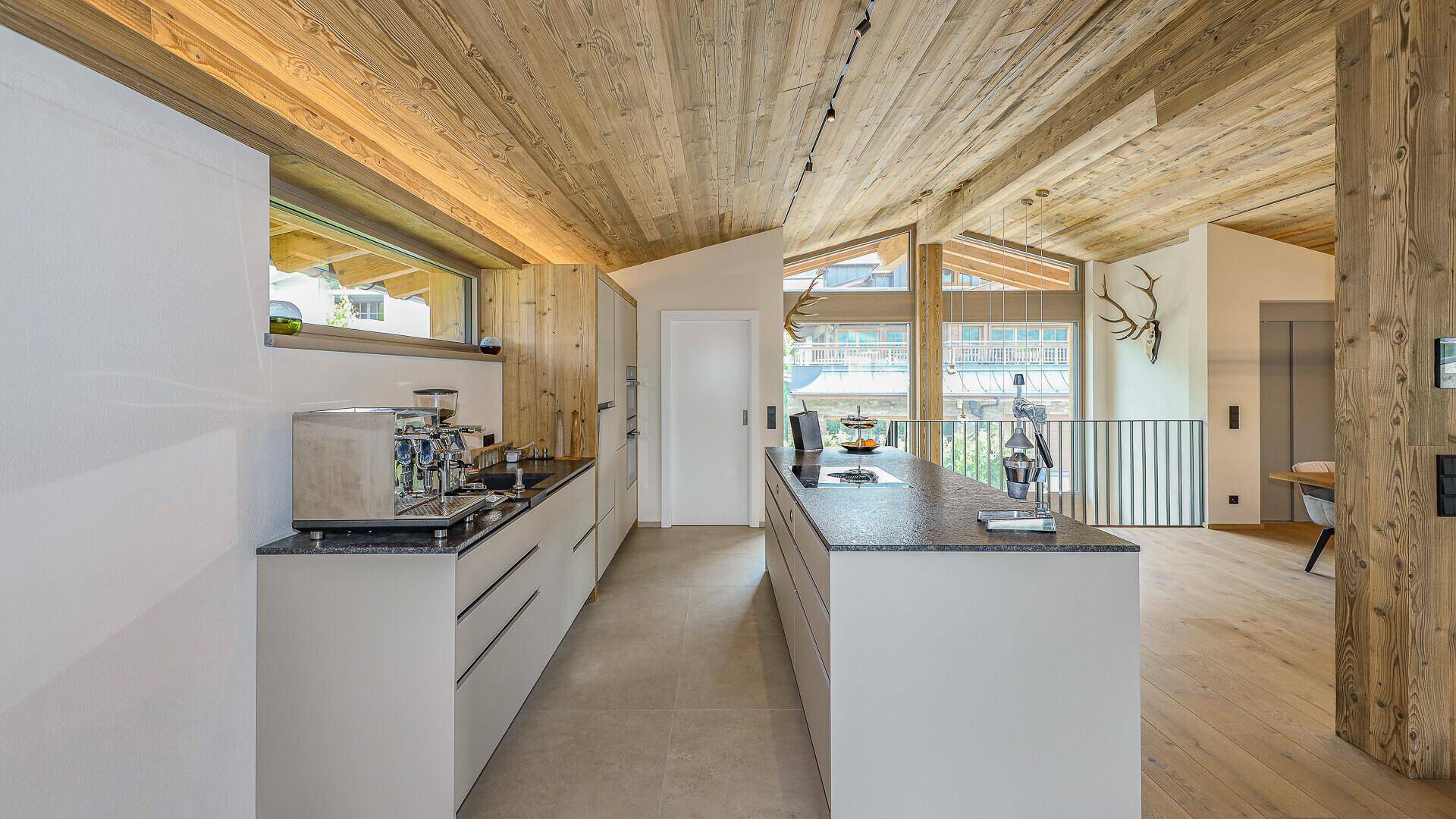 Moderne Küche mit Kücheninsel, Granitarbeitsplatte und hochwertigen Einbaugeräten.