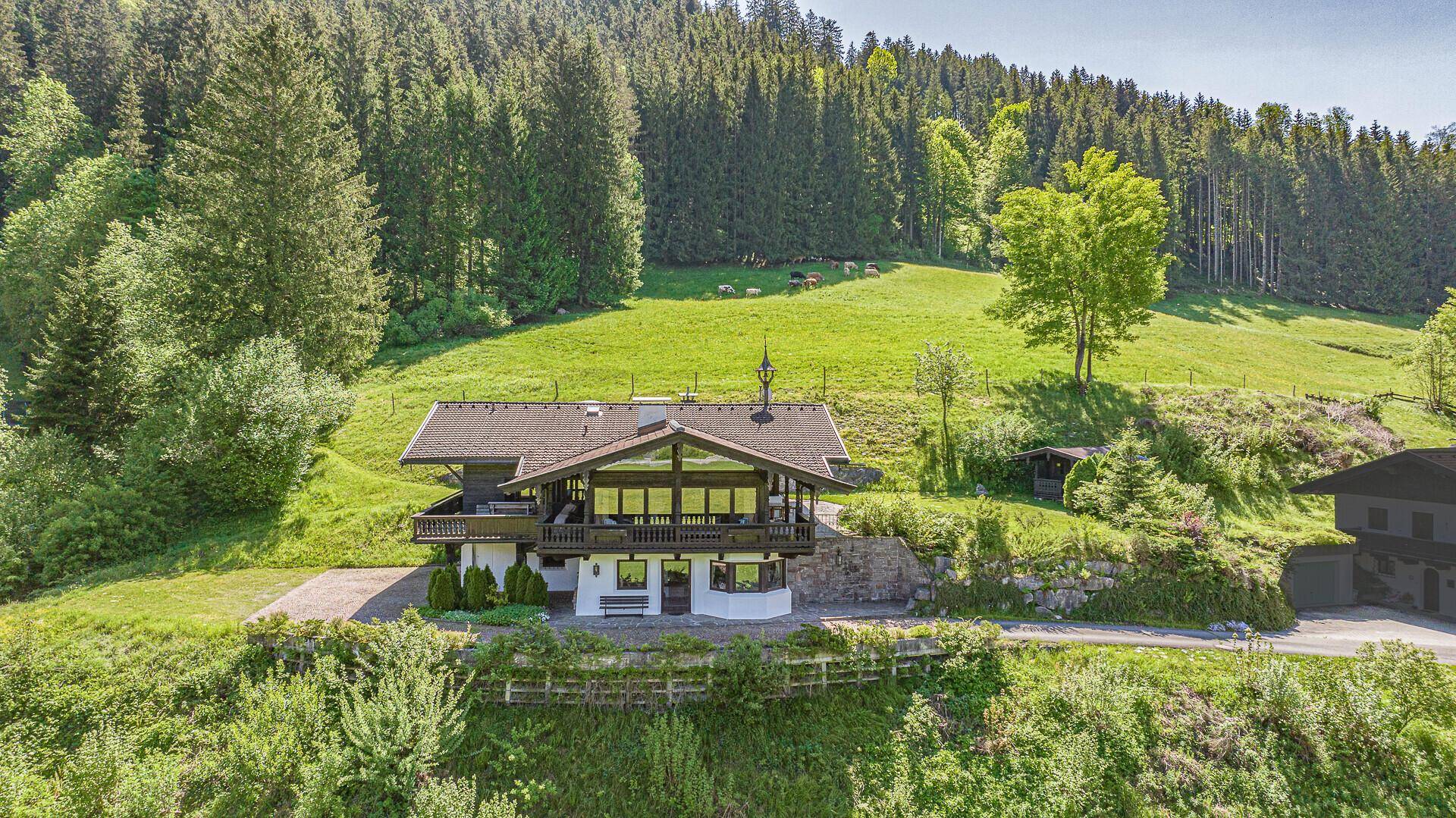 Alpenländisches Haus in idyllischer Hügellandschaft mit weitem Blick auf die Natur.