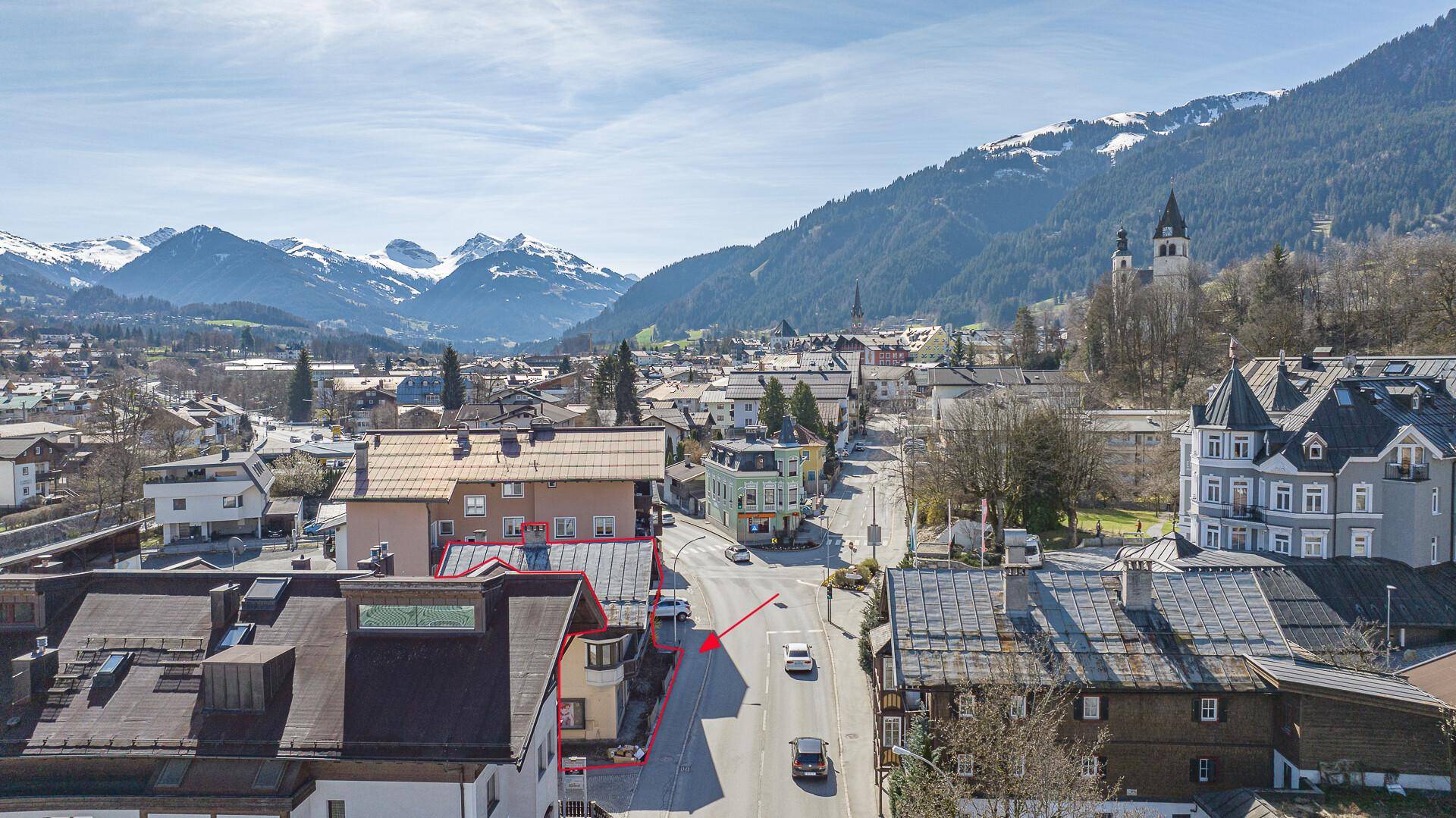 Weitläufige Luftaufnahme des Anwesens an einer Straße, eingebettet in eine malerische Berglandschaft.