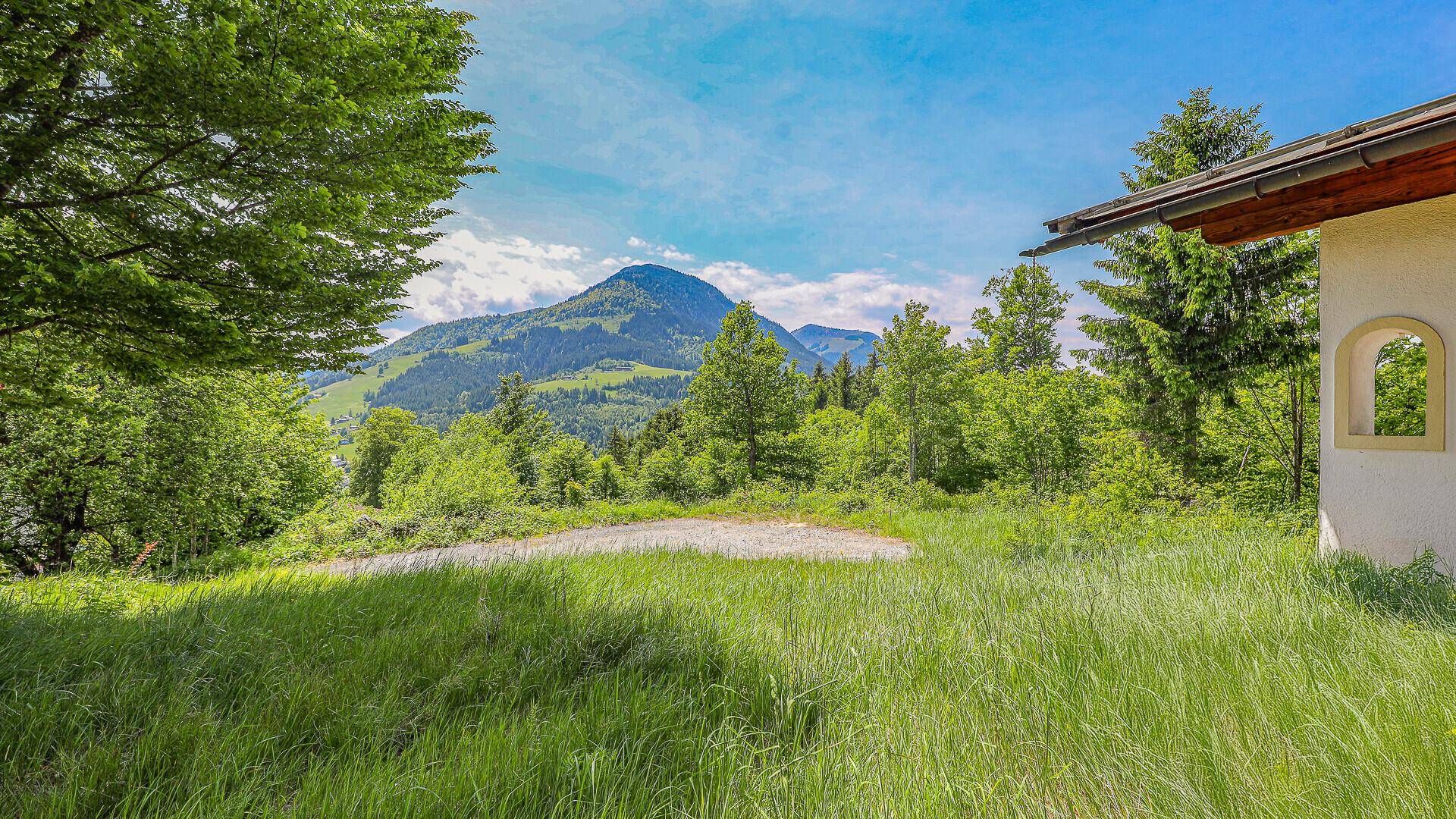 Teilansicht eines Hauses mit Blick auf die umliegende grüne Landschaft und Berge.