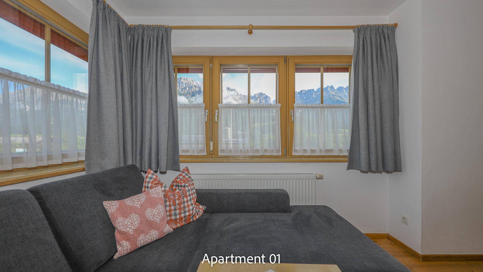 Gemütliche Sitzecke mit Bergblick durch große Fenster.