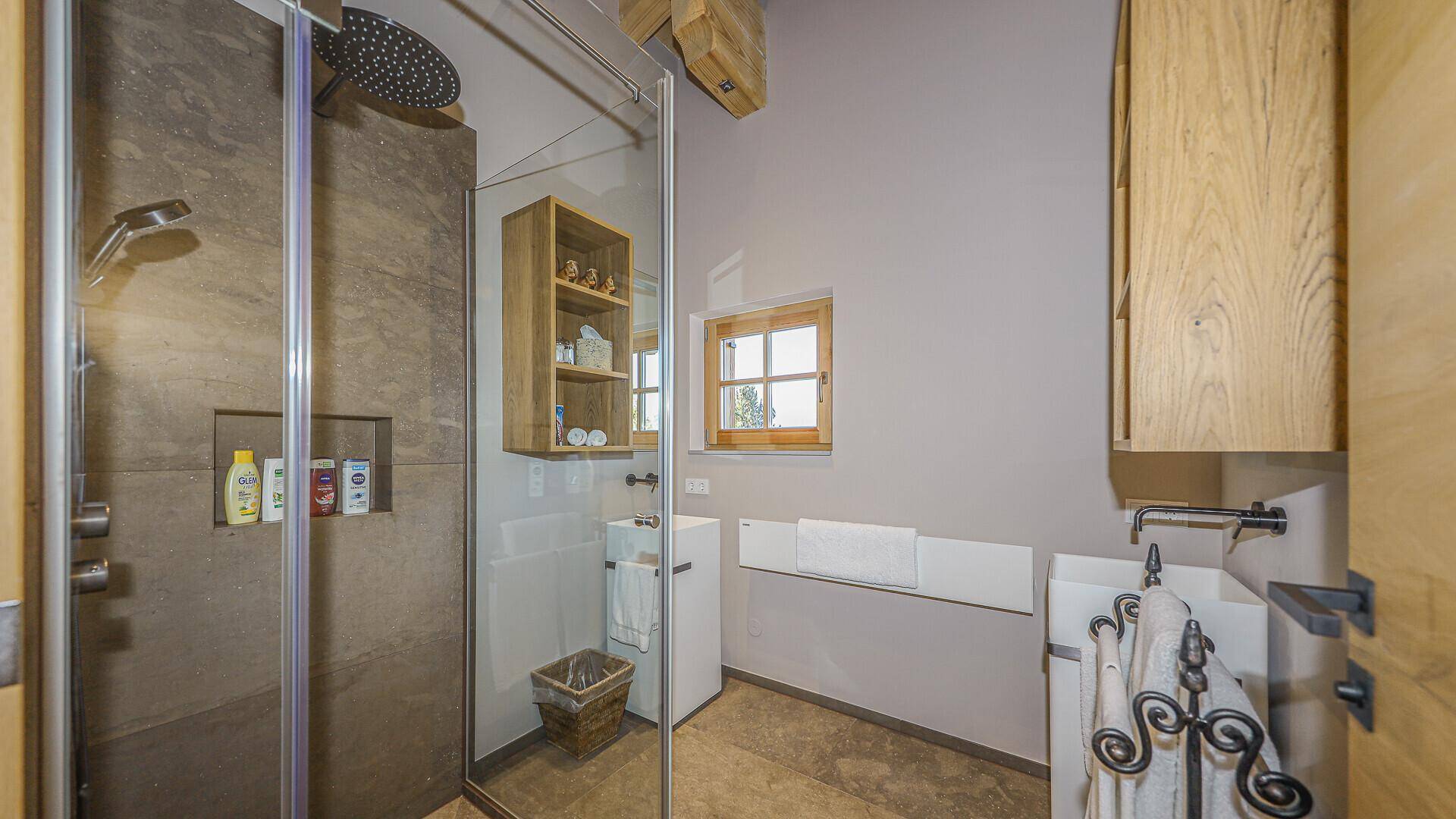 Modernes Badezimmer mit begehbarer Dusche, Einzelwaschbecken und Fenster im alpinen Stil.