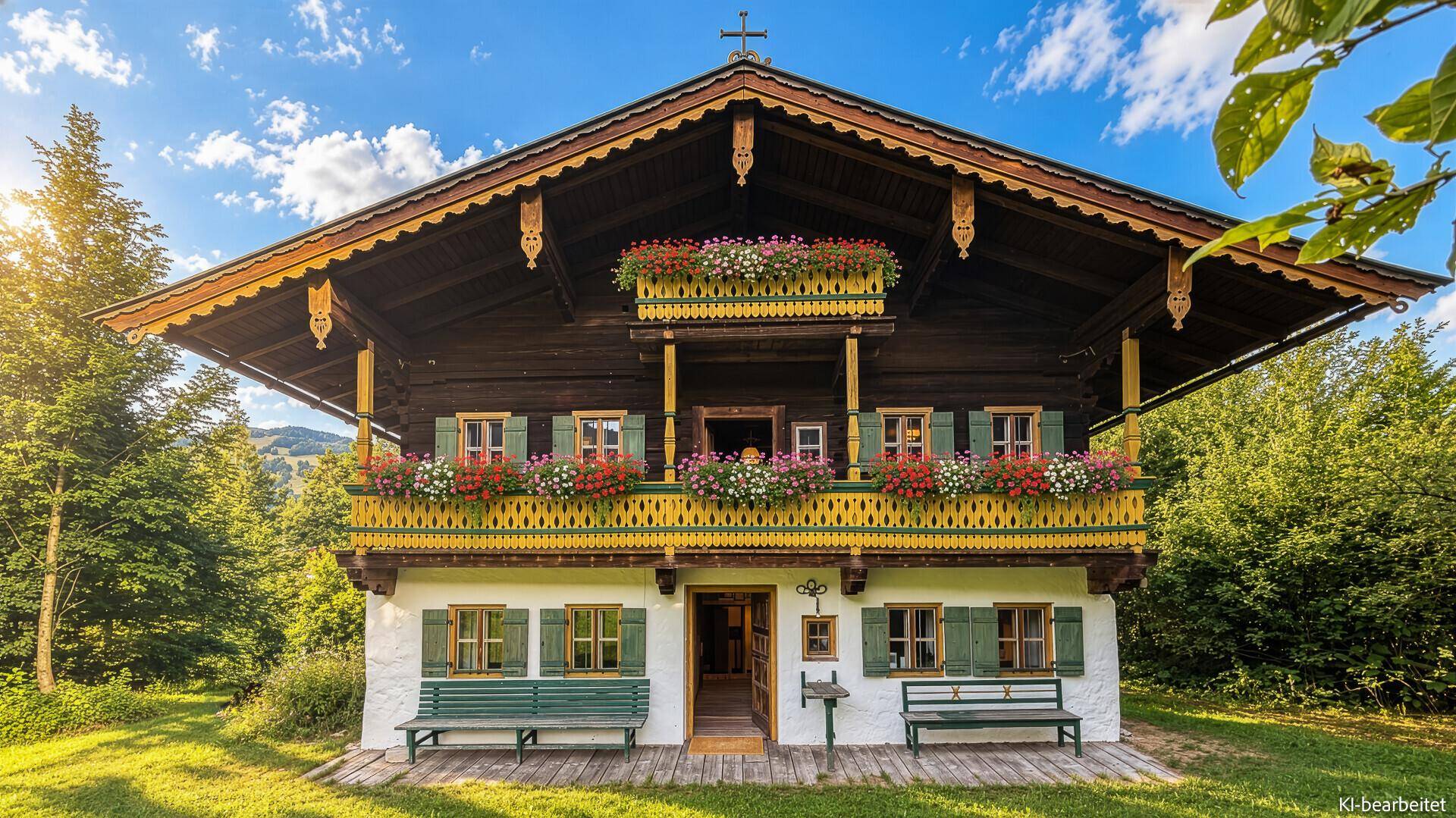Frontansicht des traditionellen bayerischen Chalets mit detailreichen Holzarbeiten und blühenden Blumenkästen.