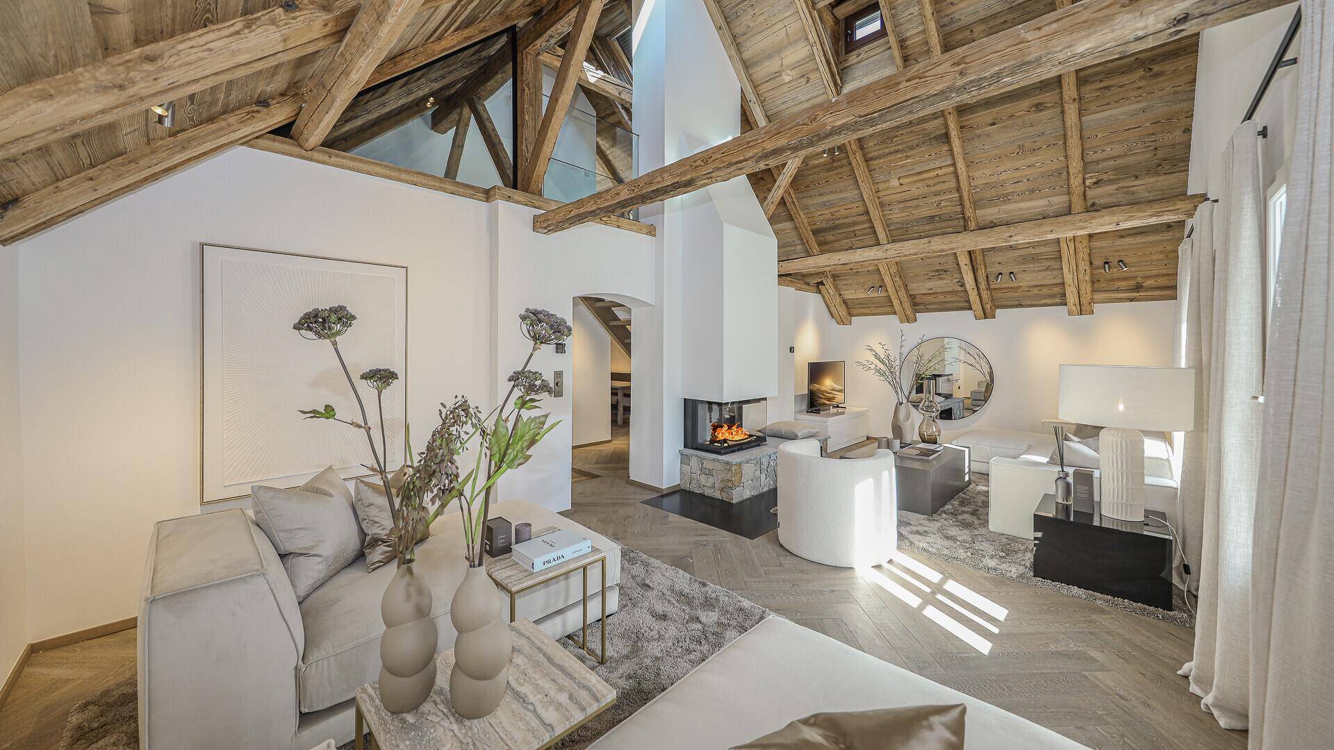 Helles Wohnzimmer mit freiliegenden Holzbalken, modernem Kamin und stilvoller Einrichtung.
