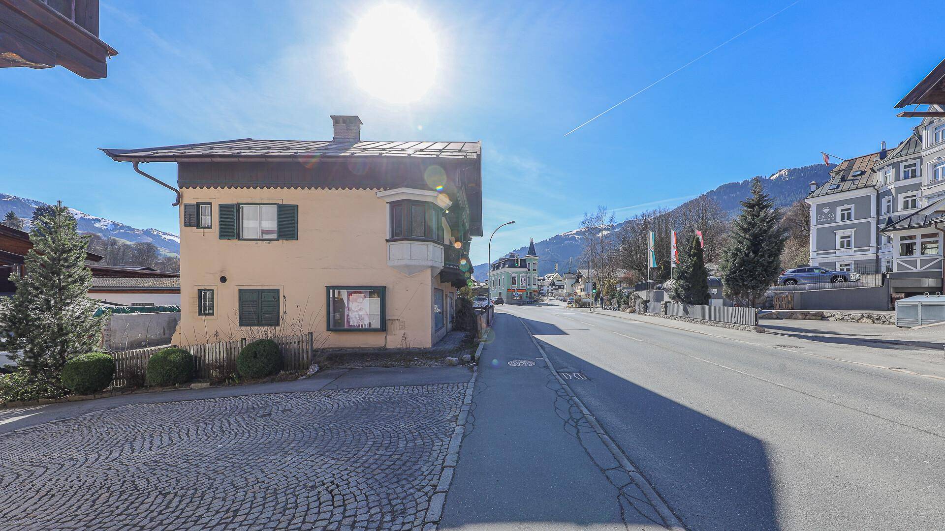 Das Gebäude an einer gepflasterten Straße unter strahlend blauem Himmel mit viel Sonnenschein.