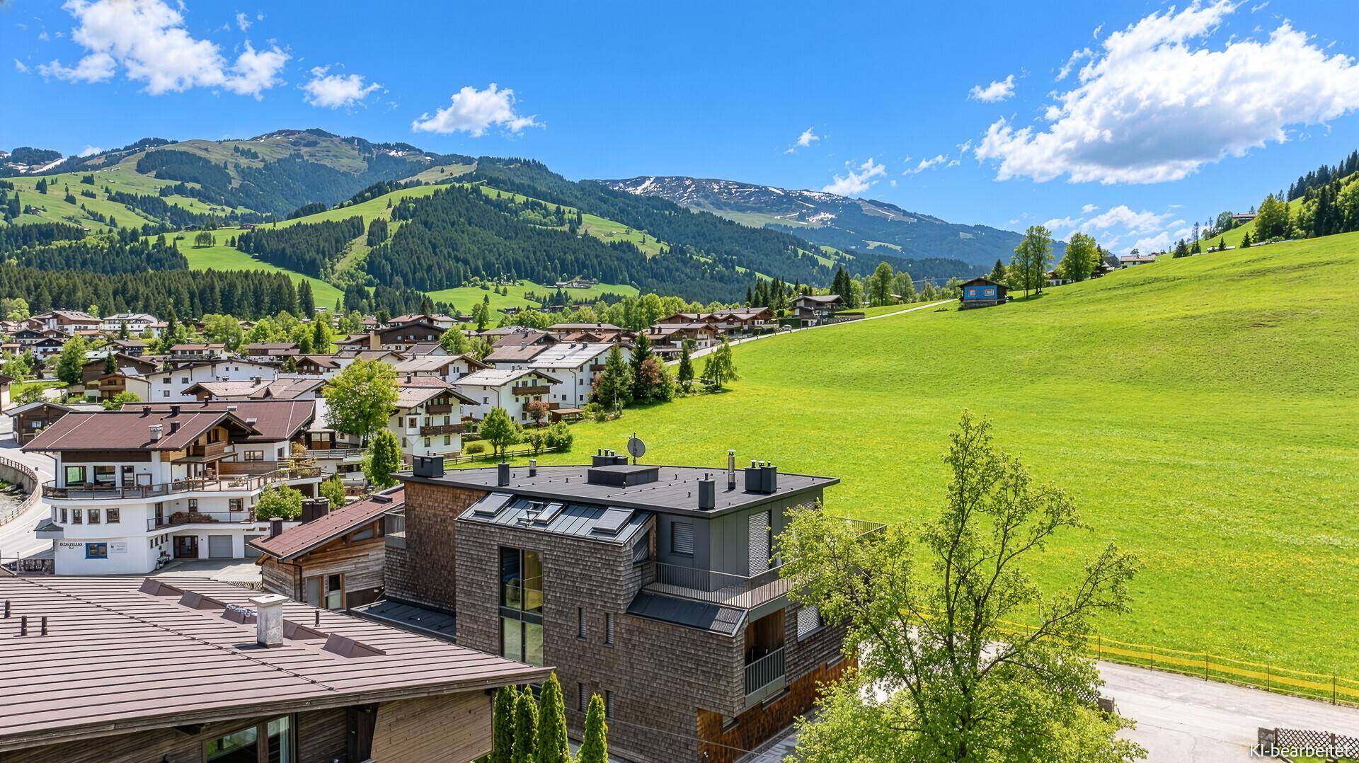 Panoramablick auf eine Wohnsiedlung in einer malerischen Berglandschaft.