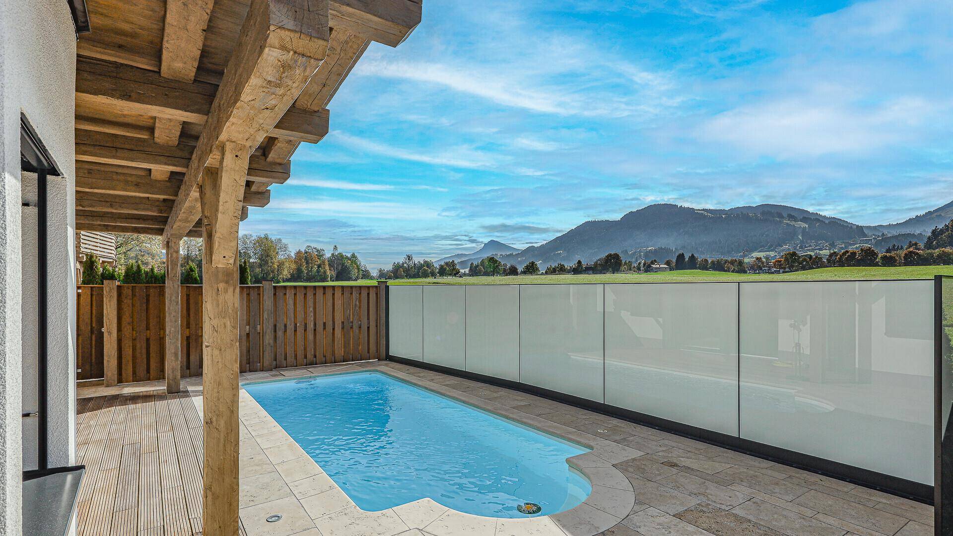 Kleiner Außenpool mit Terrasse und weitem Blick auf die grüne Hügellandschaft.
