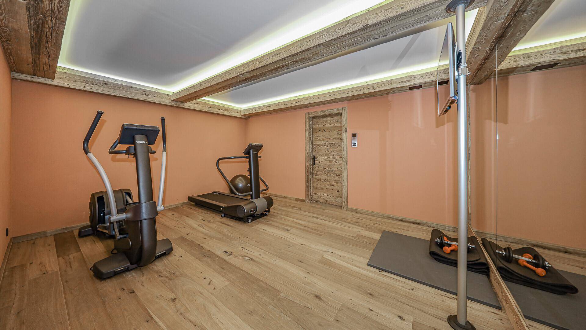 Fitnessraum mit Laufband, Crosstrainer und Hanteln für das persönliche Training.