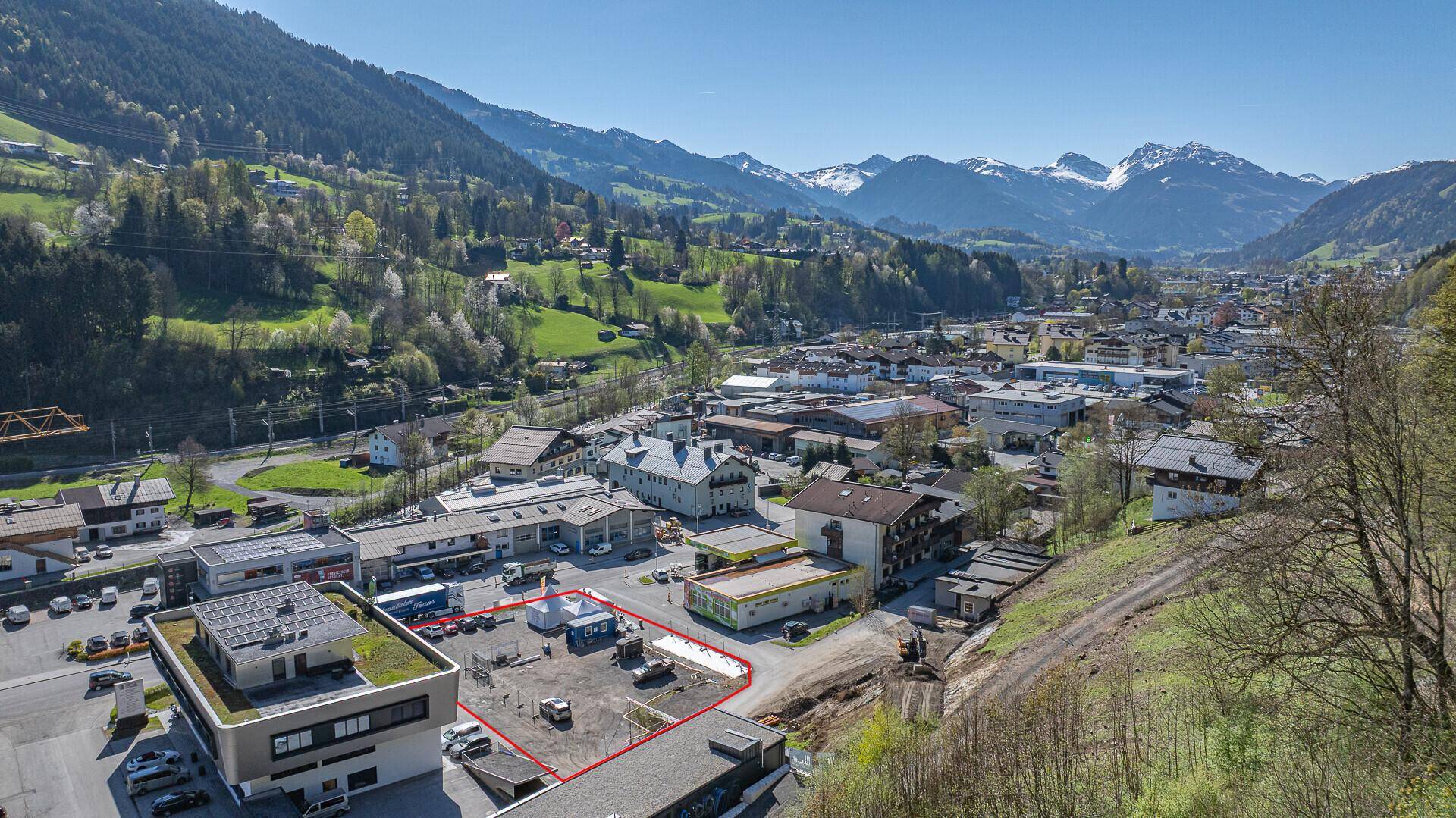 Luftaufnahme einer malerischen Bergstadt mit dem markierten Grundstück und weitem Blick.
