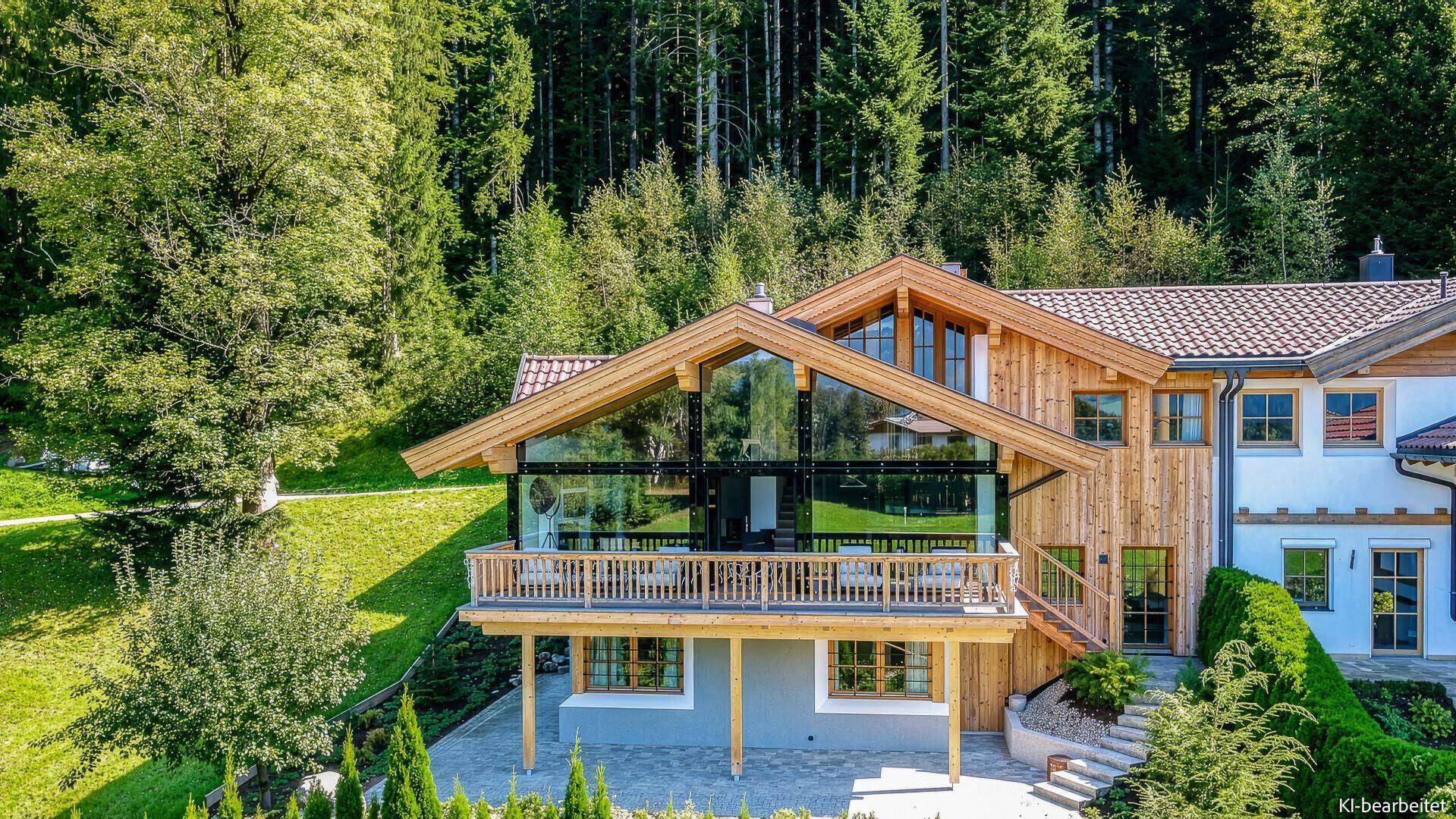 Attraktives Chalet mit Holzfassade, großen Glasflächen und gepflegtem Garten in alpiner Umgebung.