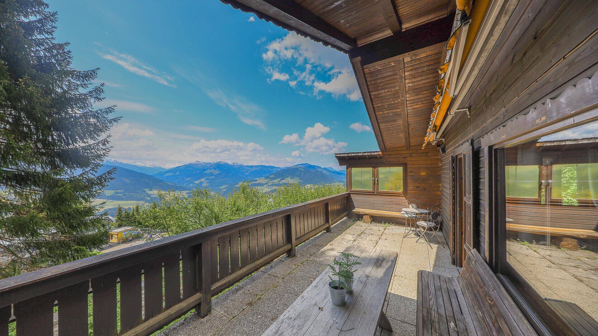 Geräumige Terrasse mit Holzbalkon und Sitzgelegenheiten, bietet einen atemberaubenden Bergblick.