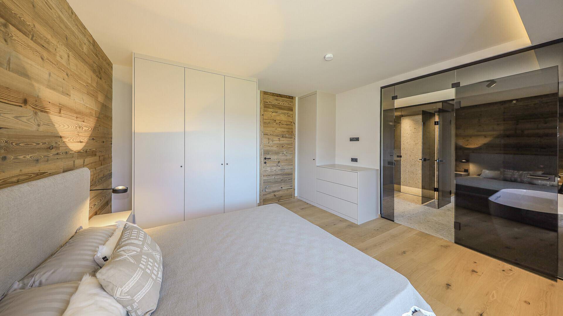 Modernes Schlafzimmer mit Einbauschränken, Holzboden und stilvoller Einrichtung.