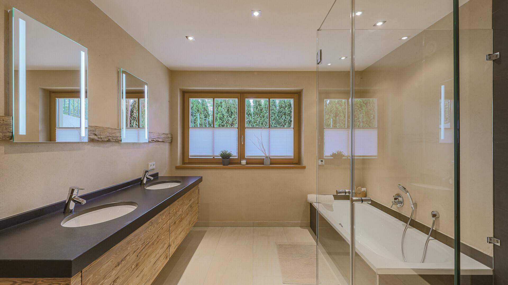 Modernes Badezimmer mit Doppelwaschbecken, Badewanne und großer begehbarer Dusche.