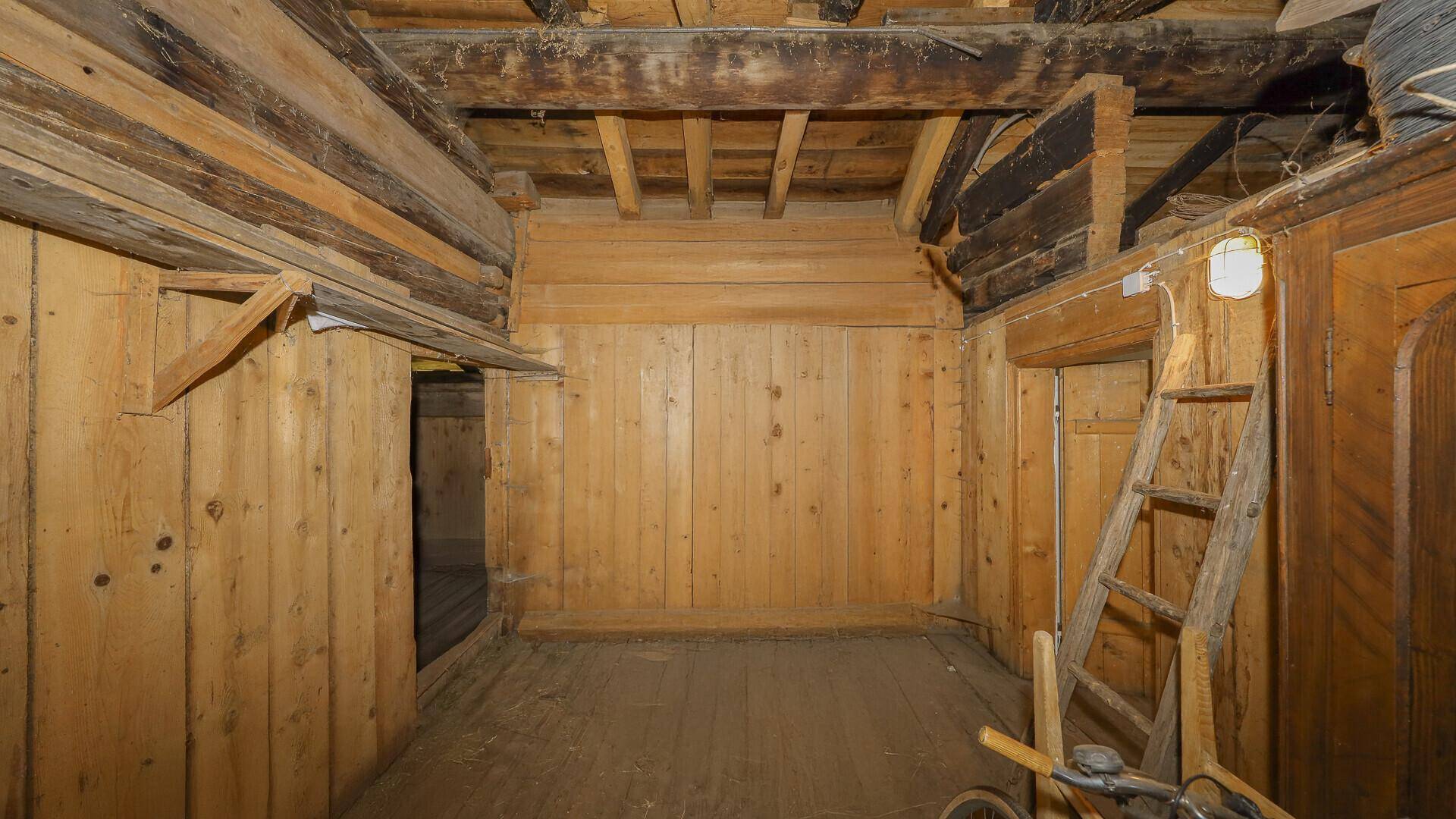 Unausgebauter Dachboden mit sichtbaren Holzbalken und viel Stauraum.
