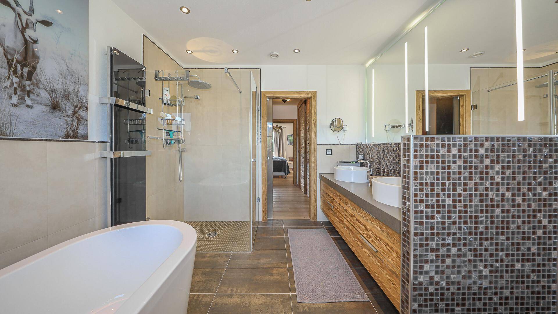 Luxuriöses Badezimmer mit freistehender Badewanne, begehbarer Dusche und Doppelwaschbecken.
